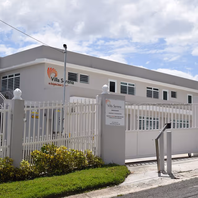 Exterior view of Insignia Caparra building, featuring a modern facade and gated entrance.
