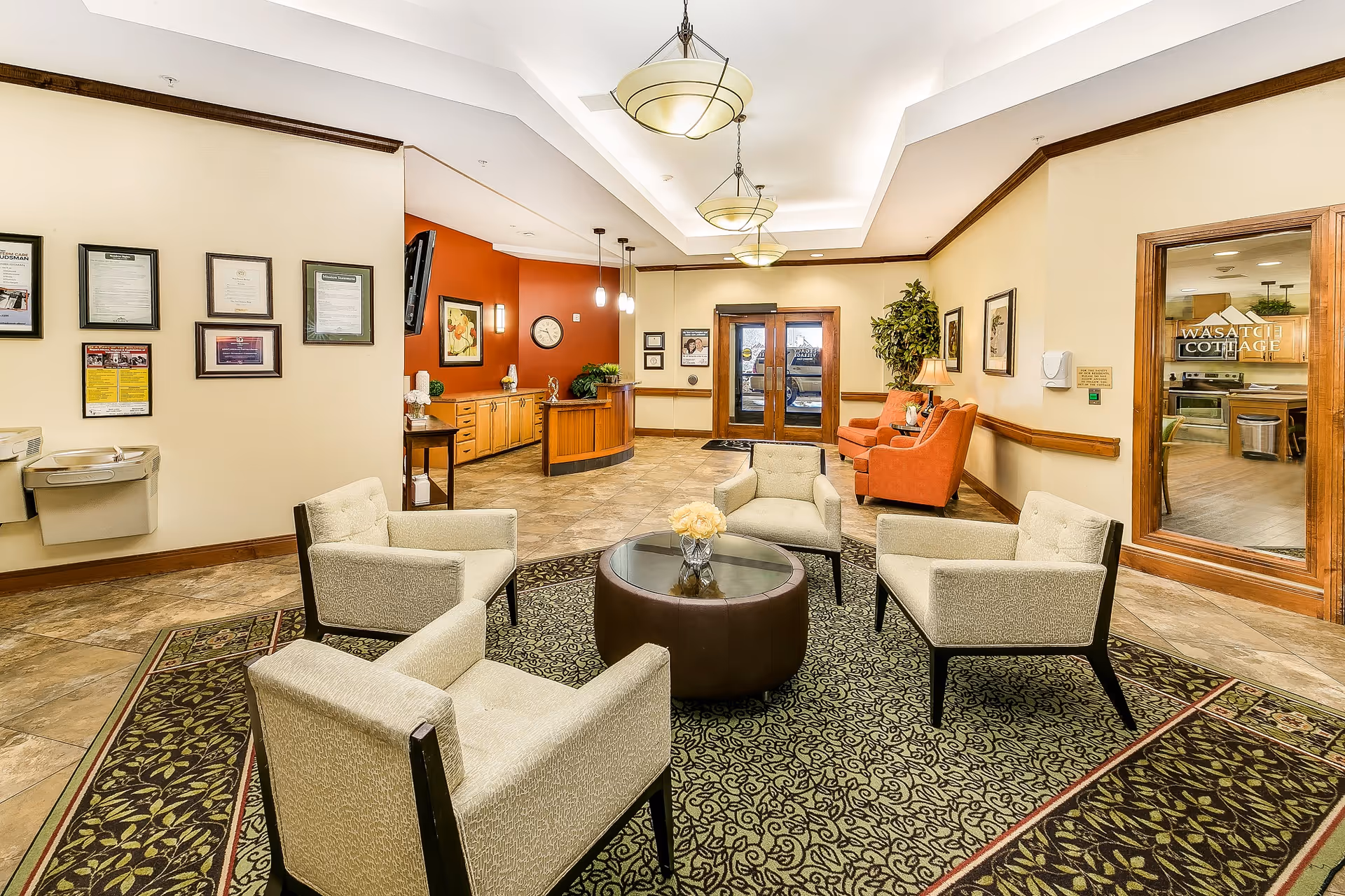 Lobby seating area with beige chairs, round coffee table, and warm lighting.