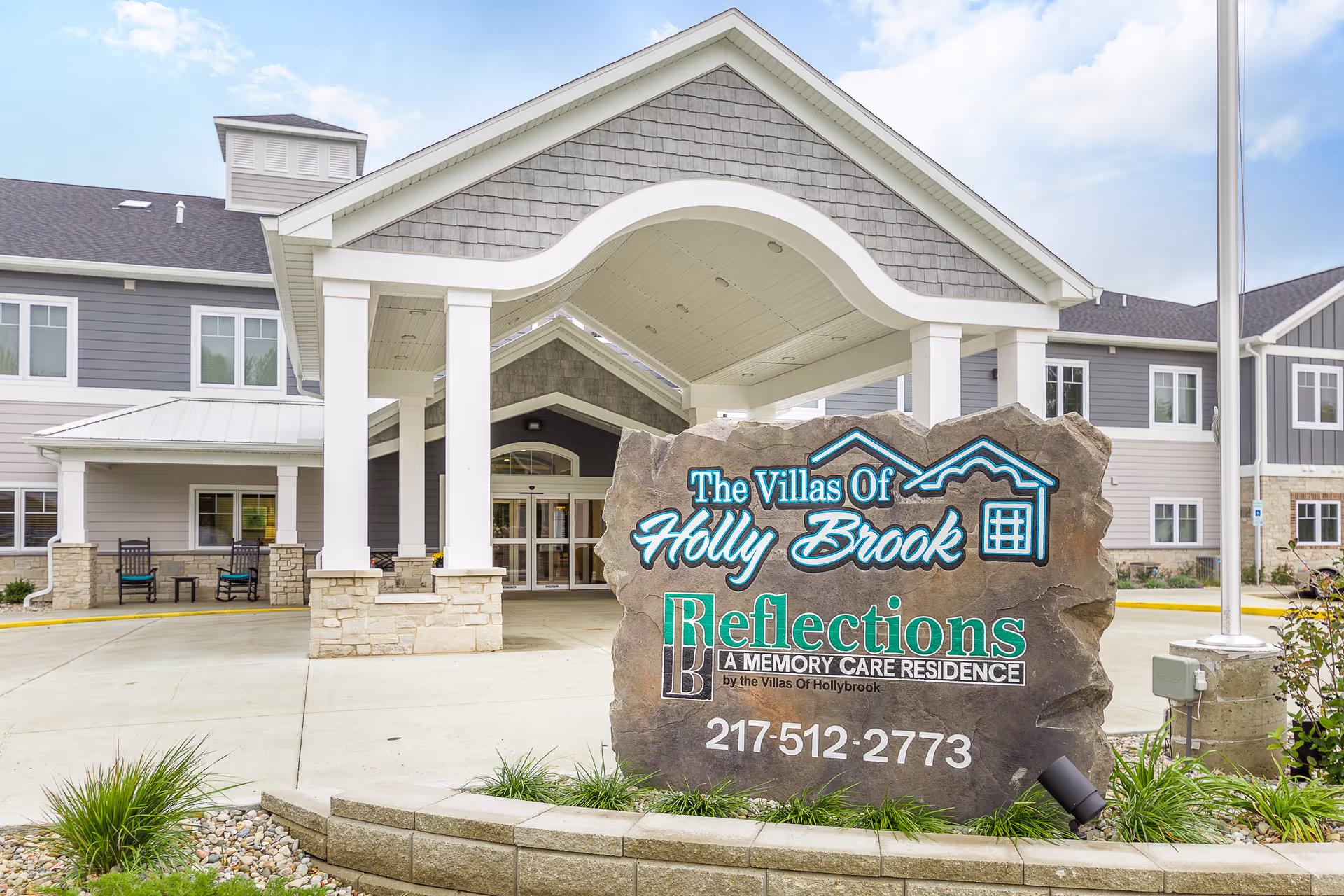 Front entrance of The Villas of Holly Brook with a large stone sign.