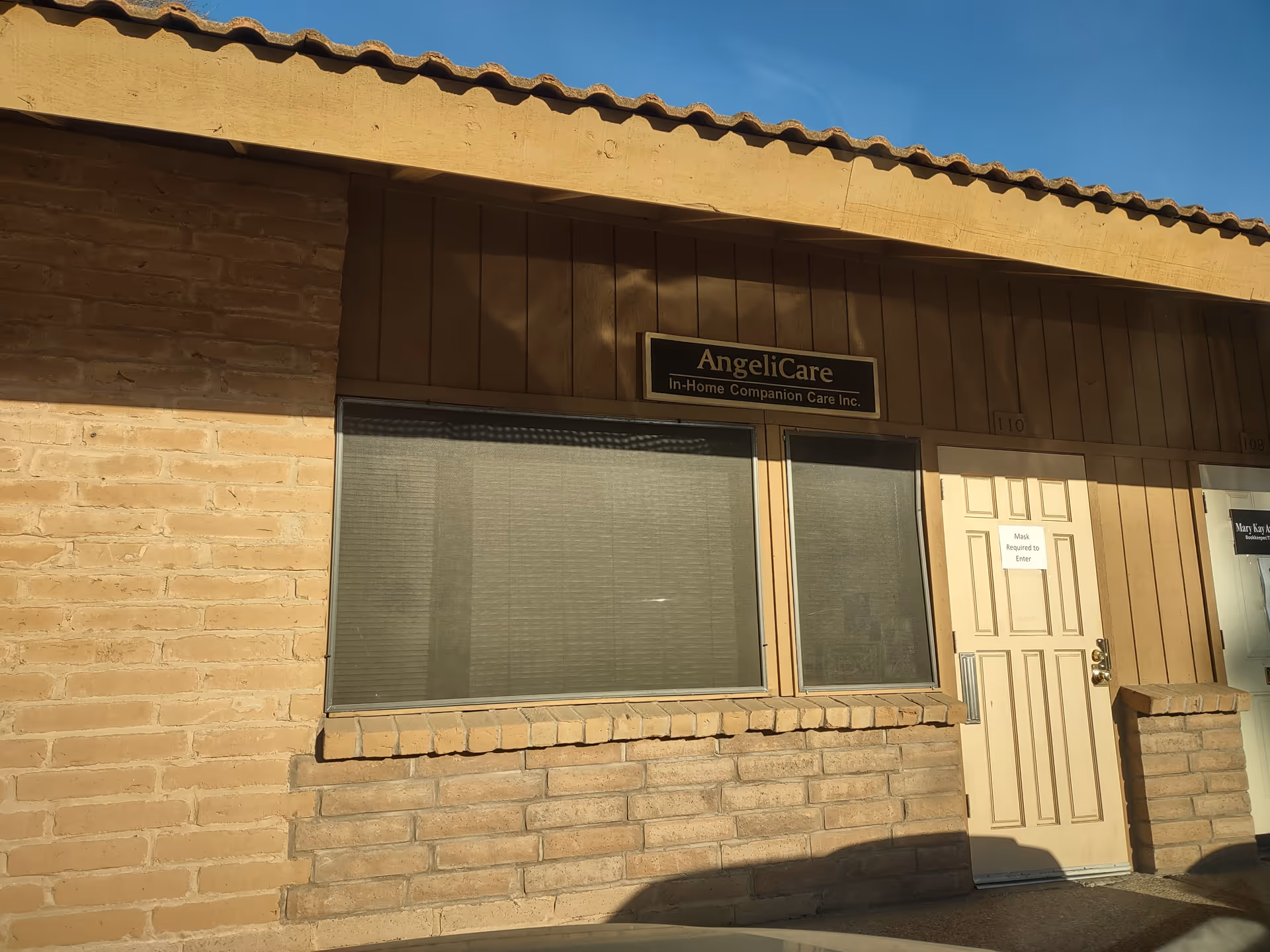 Exterior view of a brick building with a sign reading AngeliCare In-Home Companion Care.