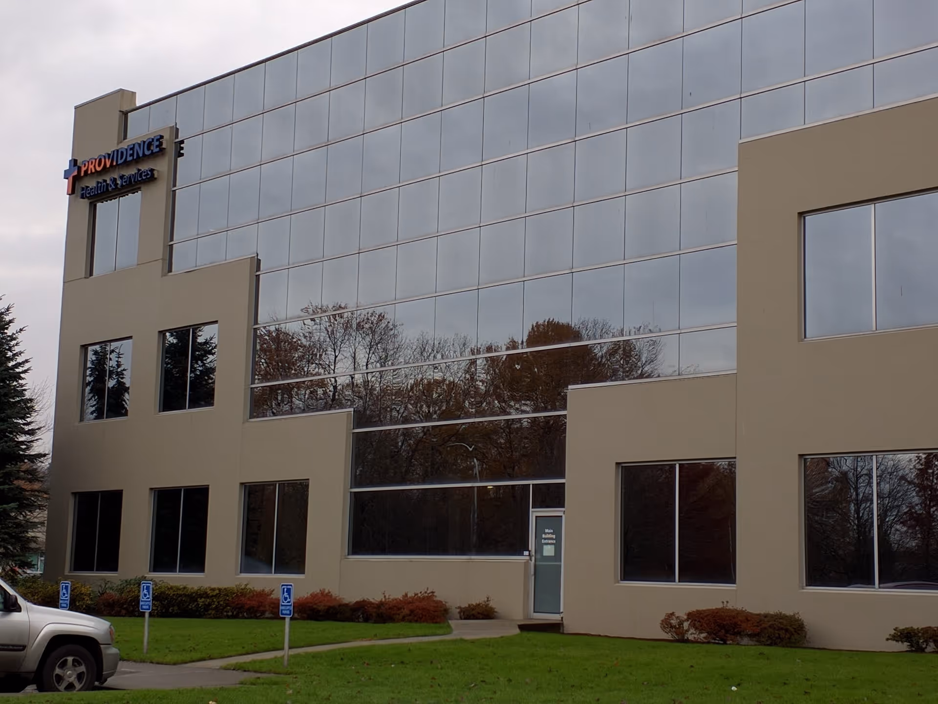 Modern beige building with expansive glass facade and Providence Health & Services sign.