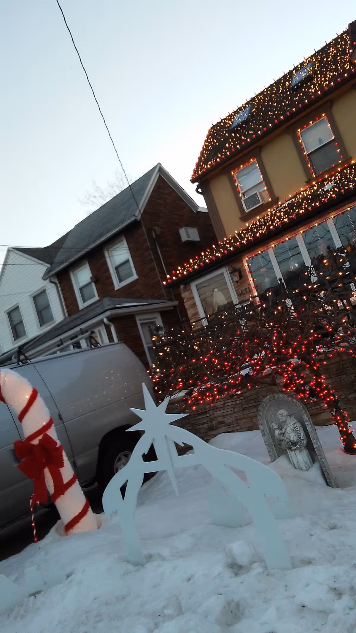 Snow-covered street view with festive lights on the Brooklyn Boulevard ALP building exterior.