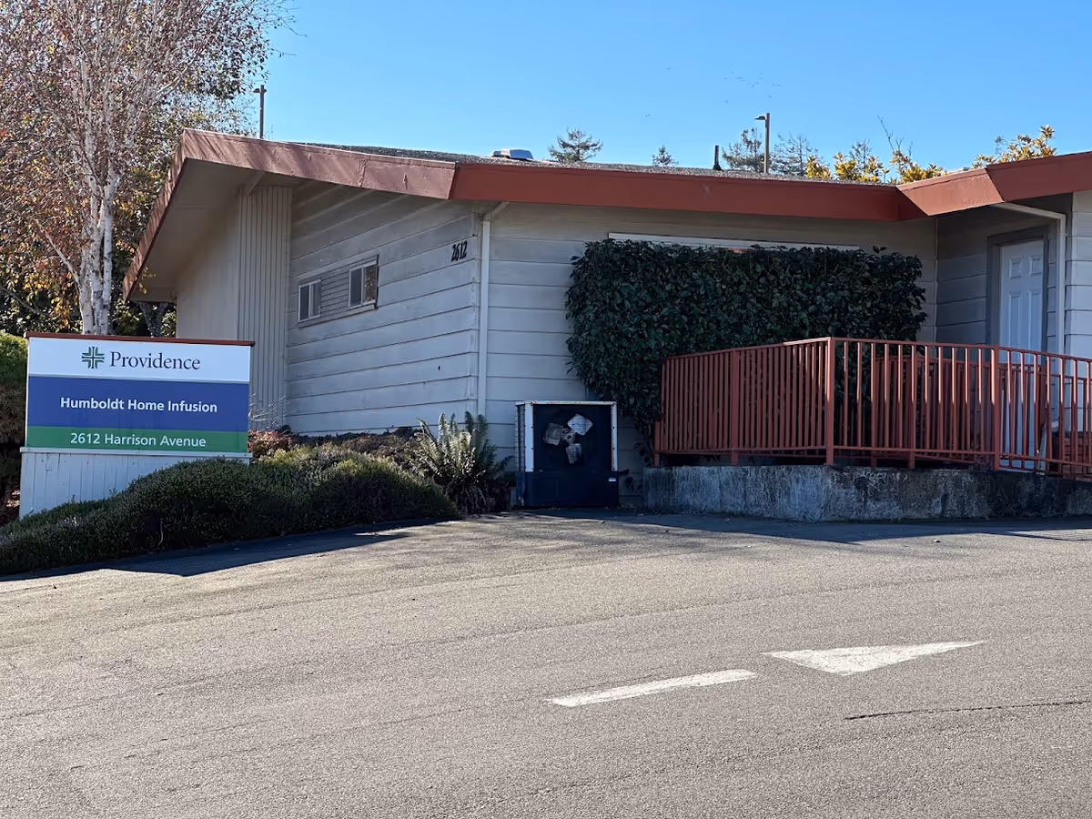 Exterior view of Providence Humboldt Home Infusion building with sign and red railing.