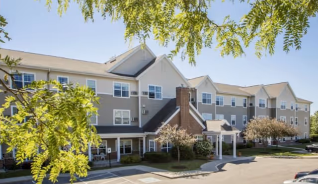 Exterior view of a Providers Inc senior living facility with entrance and parking.