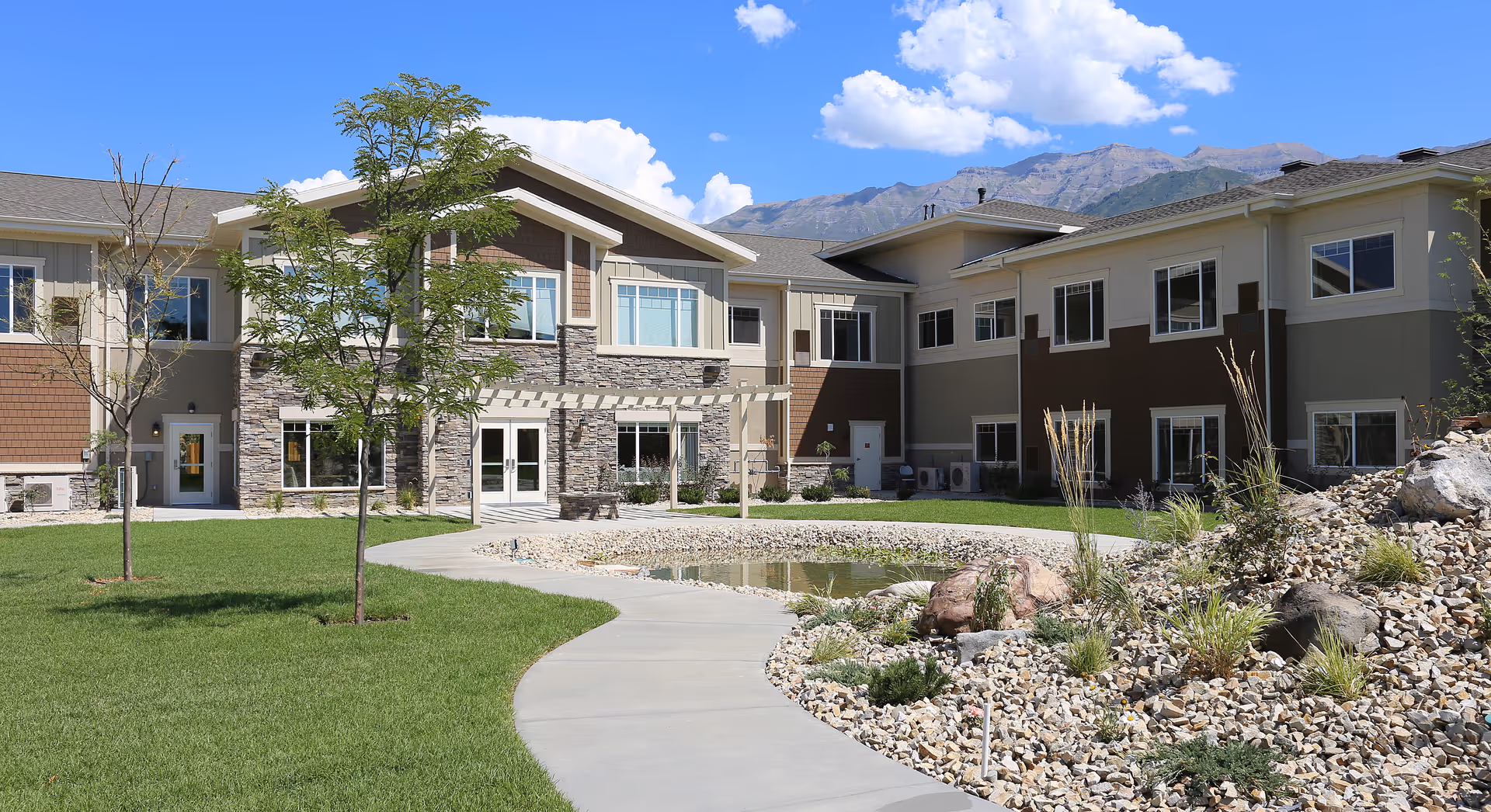 Exterior view of Covington Lehi facility with landscaped courtyard, pond, and curved walkway.