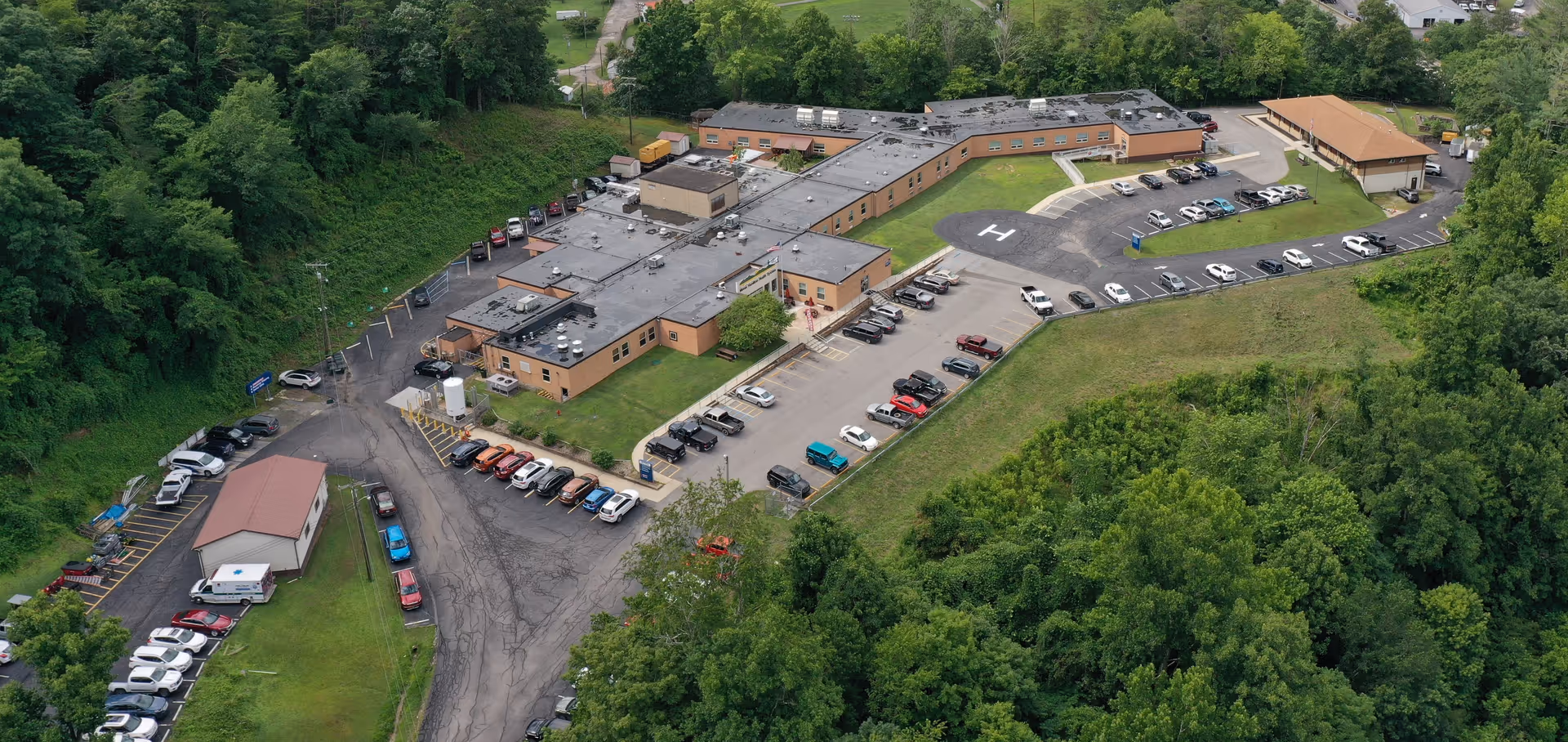 Aerial view of Minnie Hamilton Health Care building with parking lot and surrounding trees.