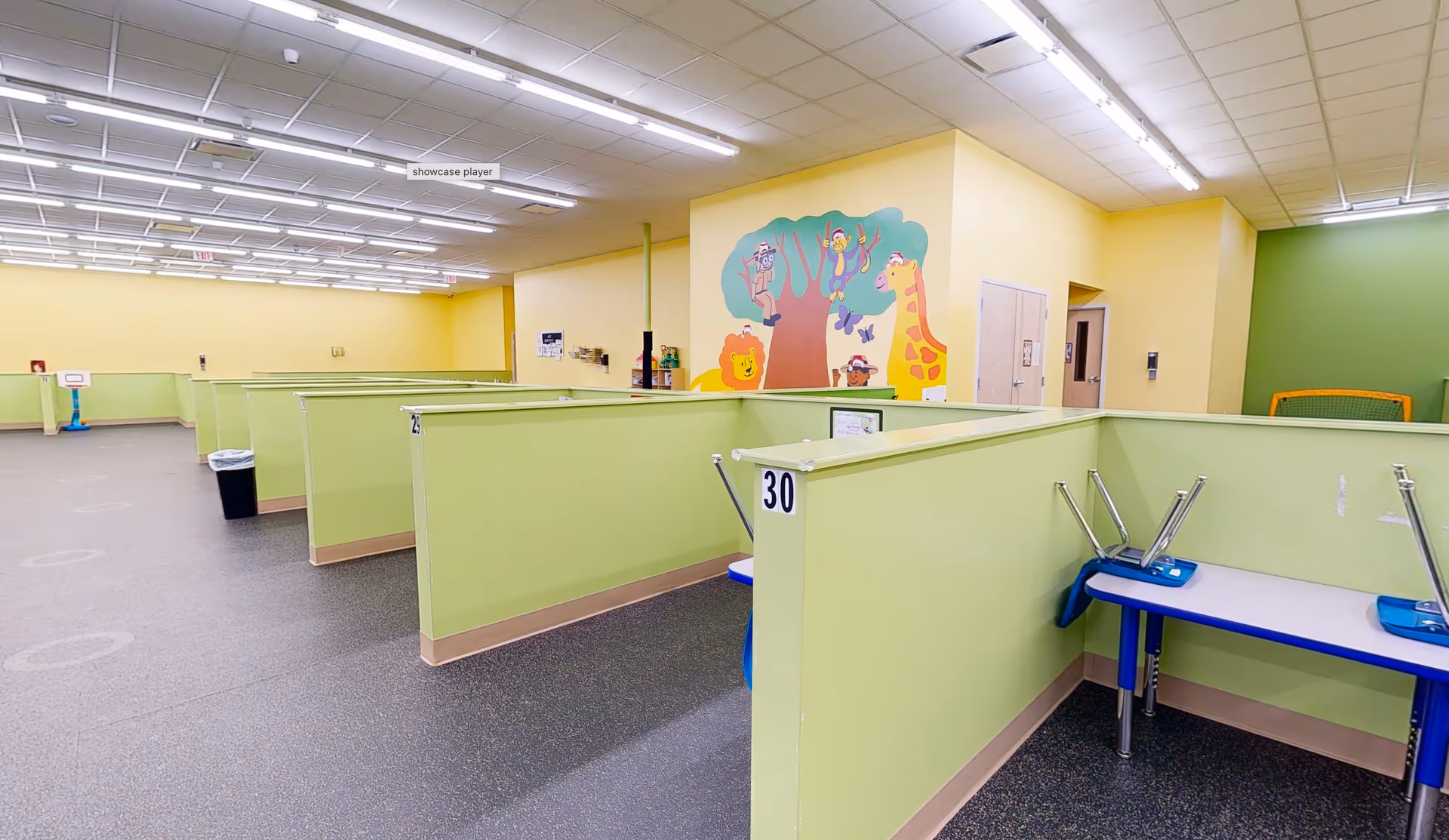 Bright therapy center with lime cubicle partitions and a colorful mural.