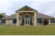 Front view of Eagle Estates senior living facility with a covered entry and green lawn.