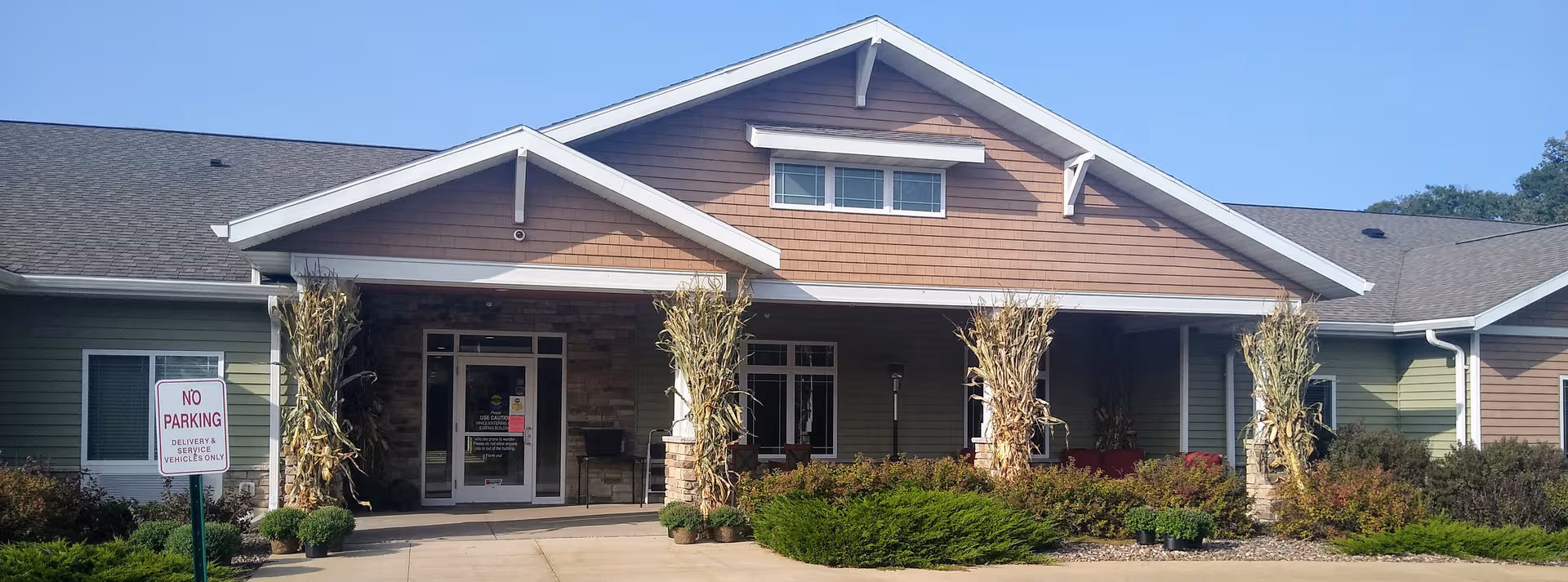 Front view of Lake Hallie Memory Care building with glass entry doors.