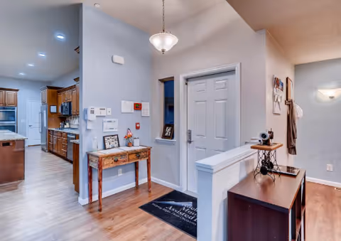 Interior of Northport Apartments senior living common area with a console table, kitchenette, and front desk.