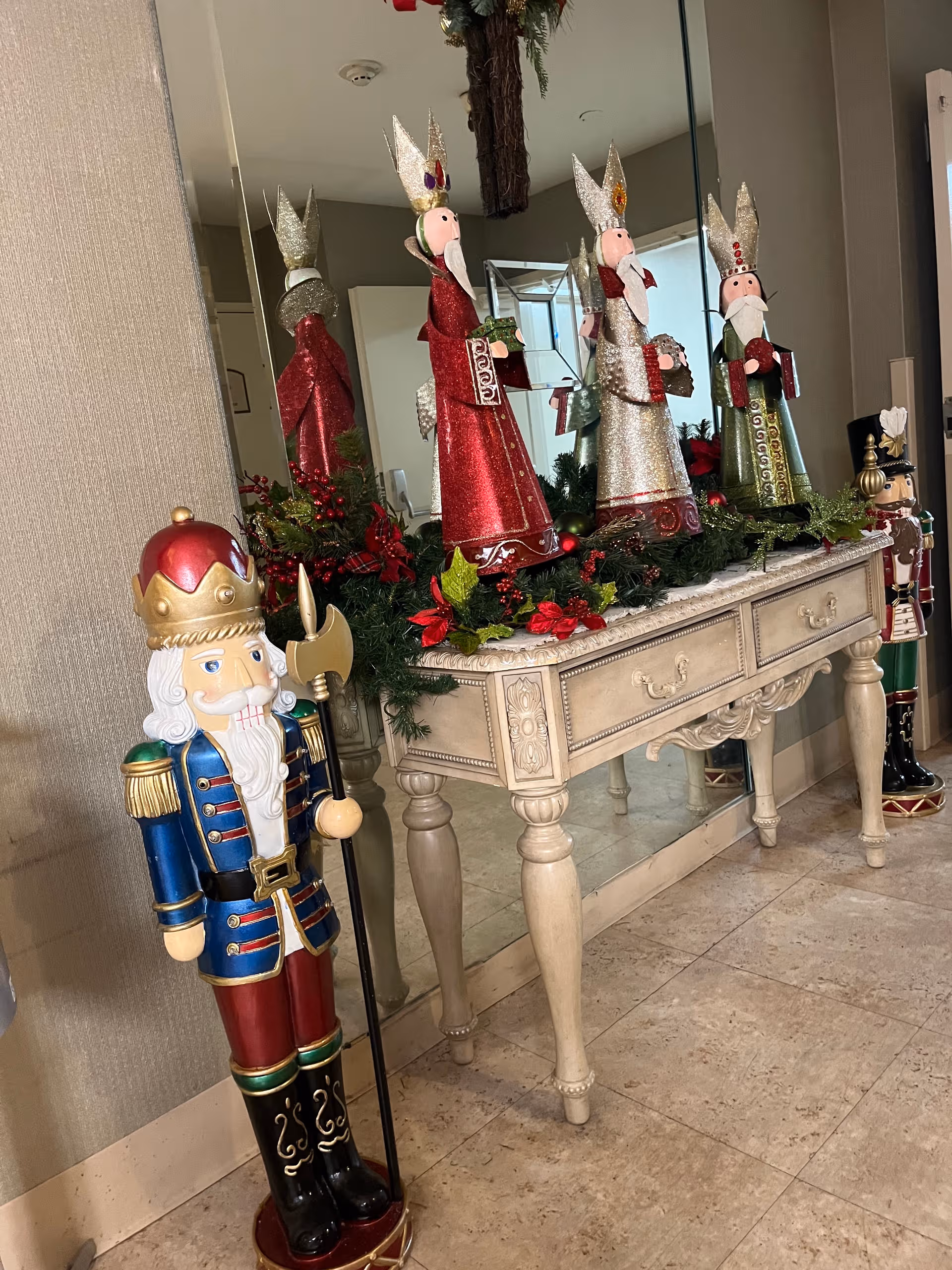 Indoor hallway decorated with holiday figures and a vintage console table.
