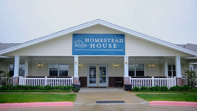 Front view of Homestead House assisted living facility with a blue banner above entrance.