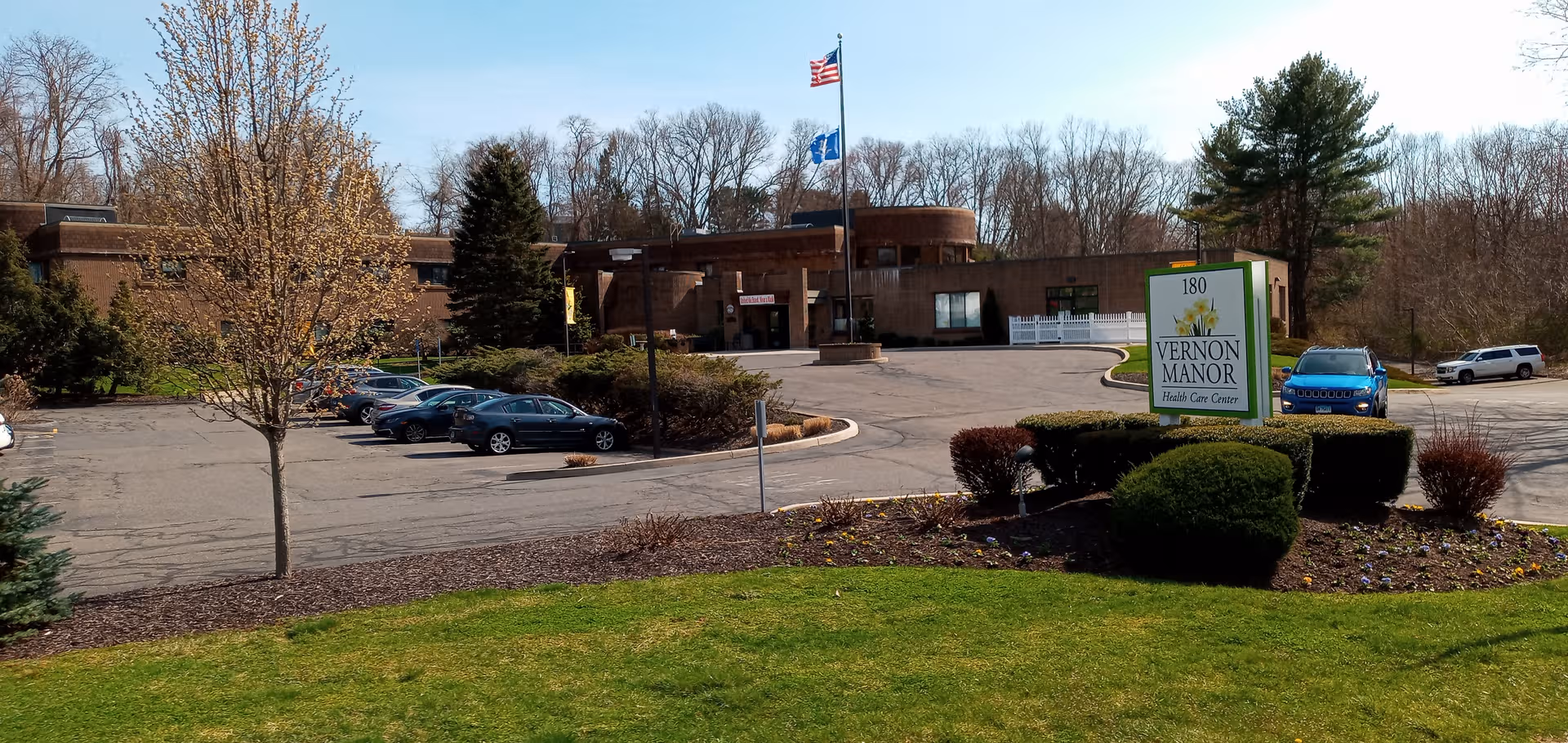 Exterior view of Vernon Rehabilitation and Healthcare Center with parking lot and landscaped grounds.