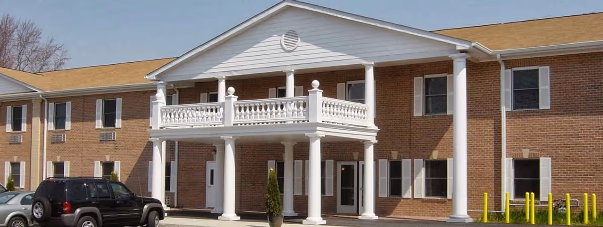 Brick assisted living facility with a white portico entrance and columns.