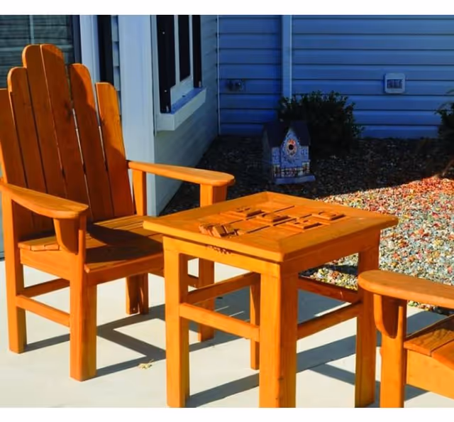 Pair of wooden outdoor chairs and a small table on a sunny patio.