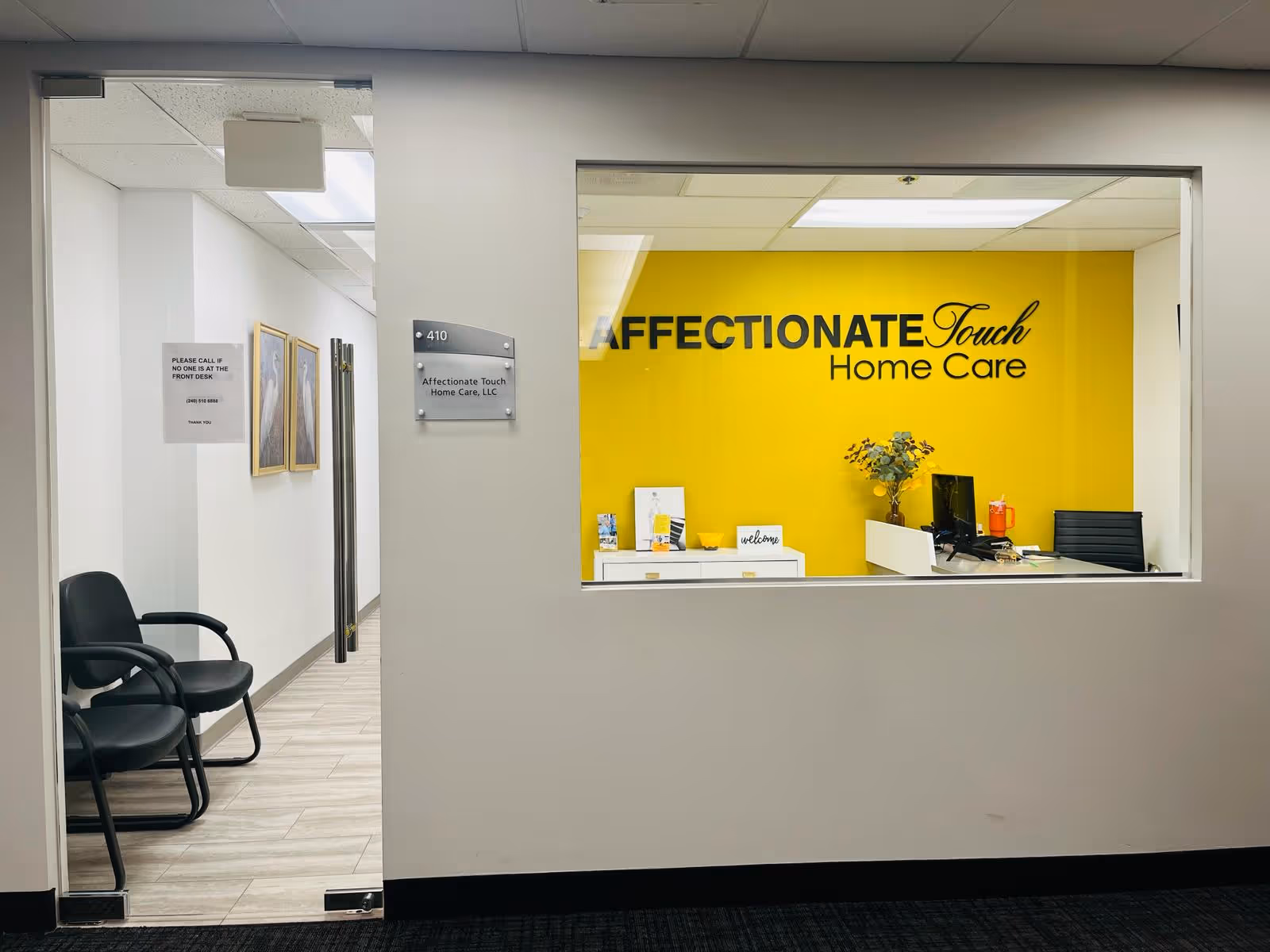 Reception window to a lobby with a yellow wall and 'Affectionate Touch Home Care' sign.