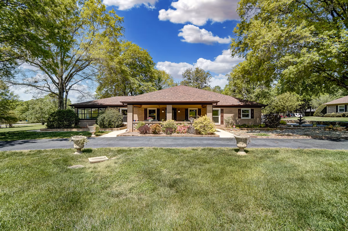 Front view of The Post at Mint Hill with landscaped entrance and trees.