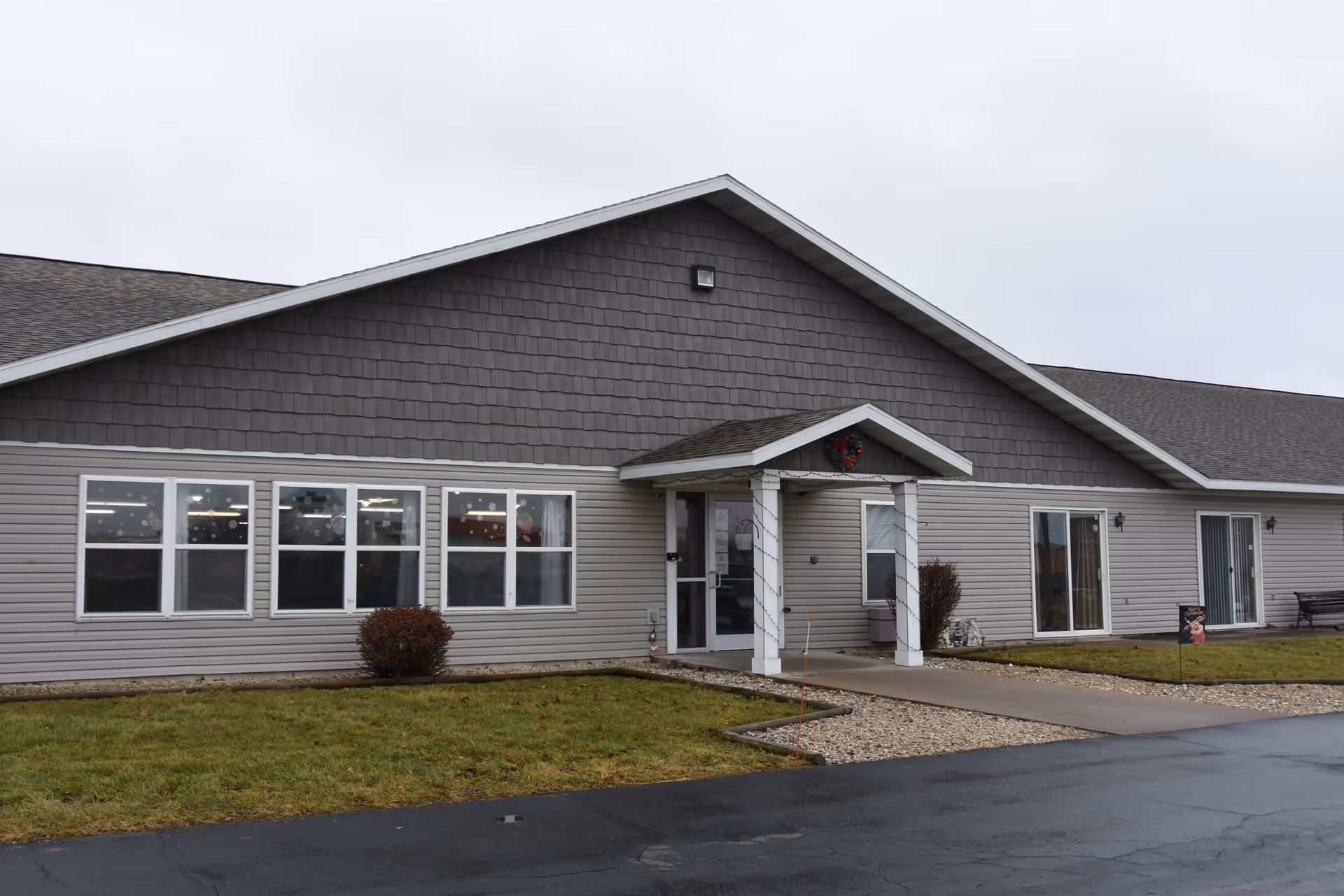 Single-story Prairie Ridge Assisted Living building with beige siding, large windows, and a front entrance.