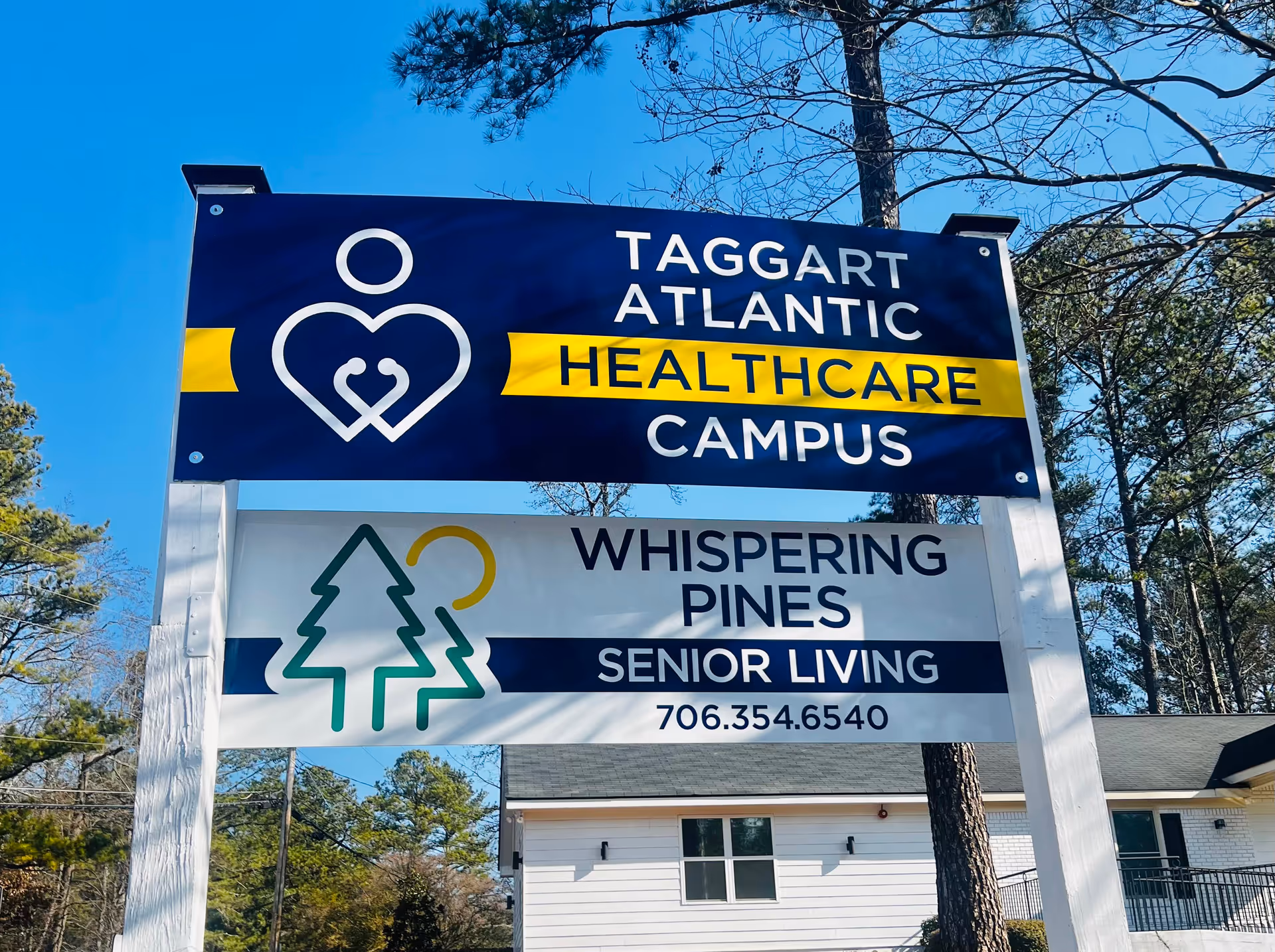 Outdoor sign for Whispering Pines Senior Living with building behind.