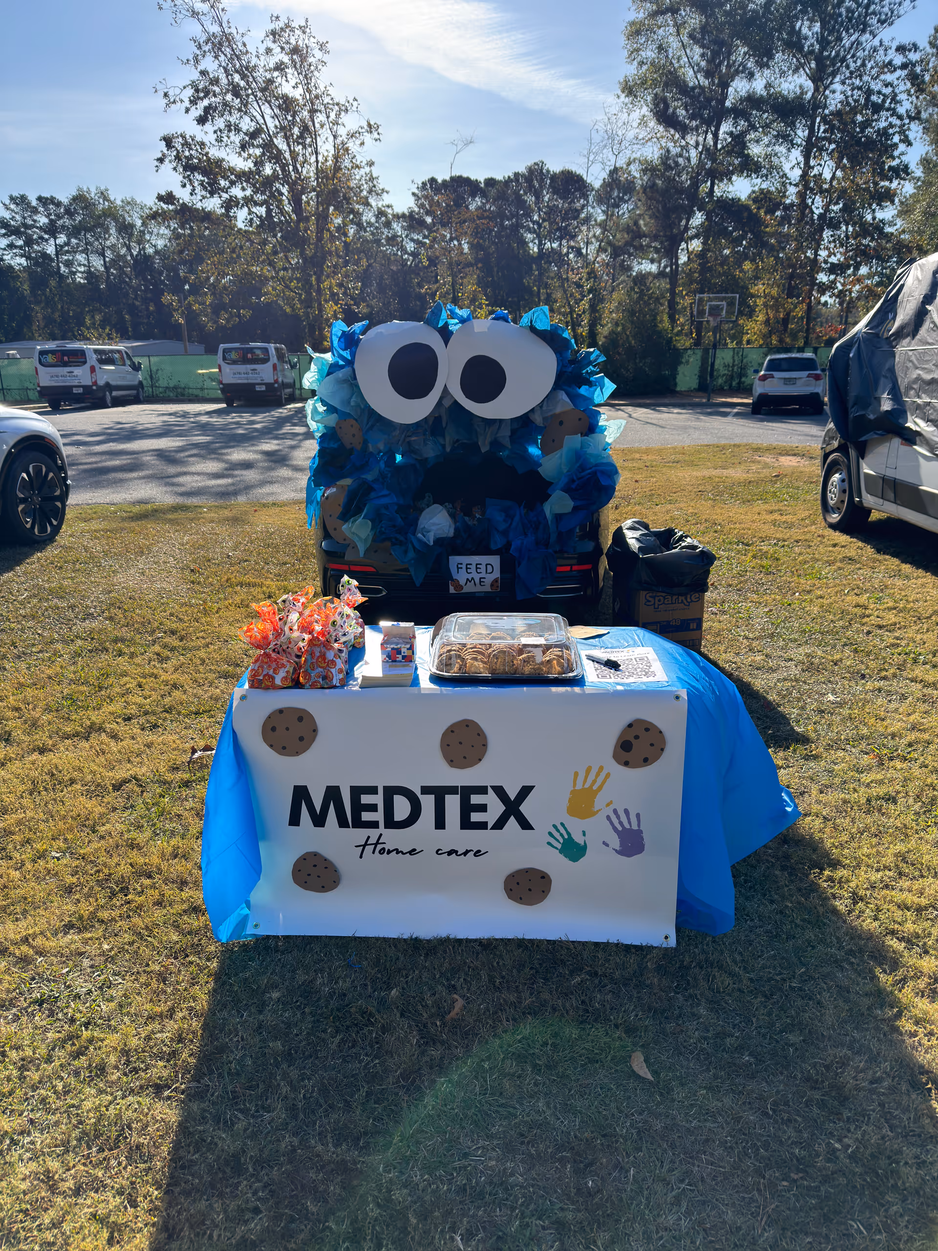 Promotional Medtex Home Care table outdoors with cookies and a blue monster car display.