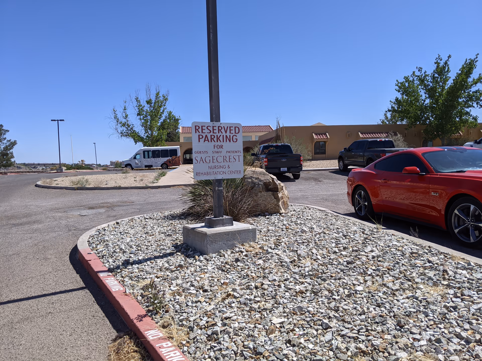 Exterior view of Calibre Post Acute campus with parked cars and a reserved parking sign.
