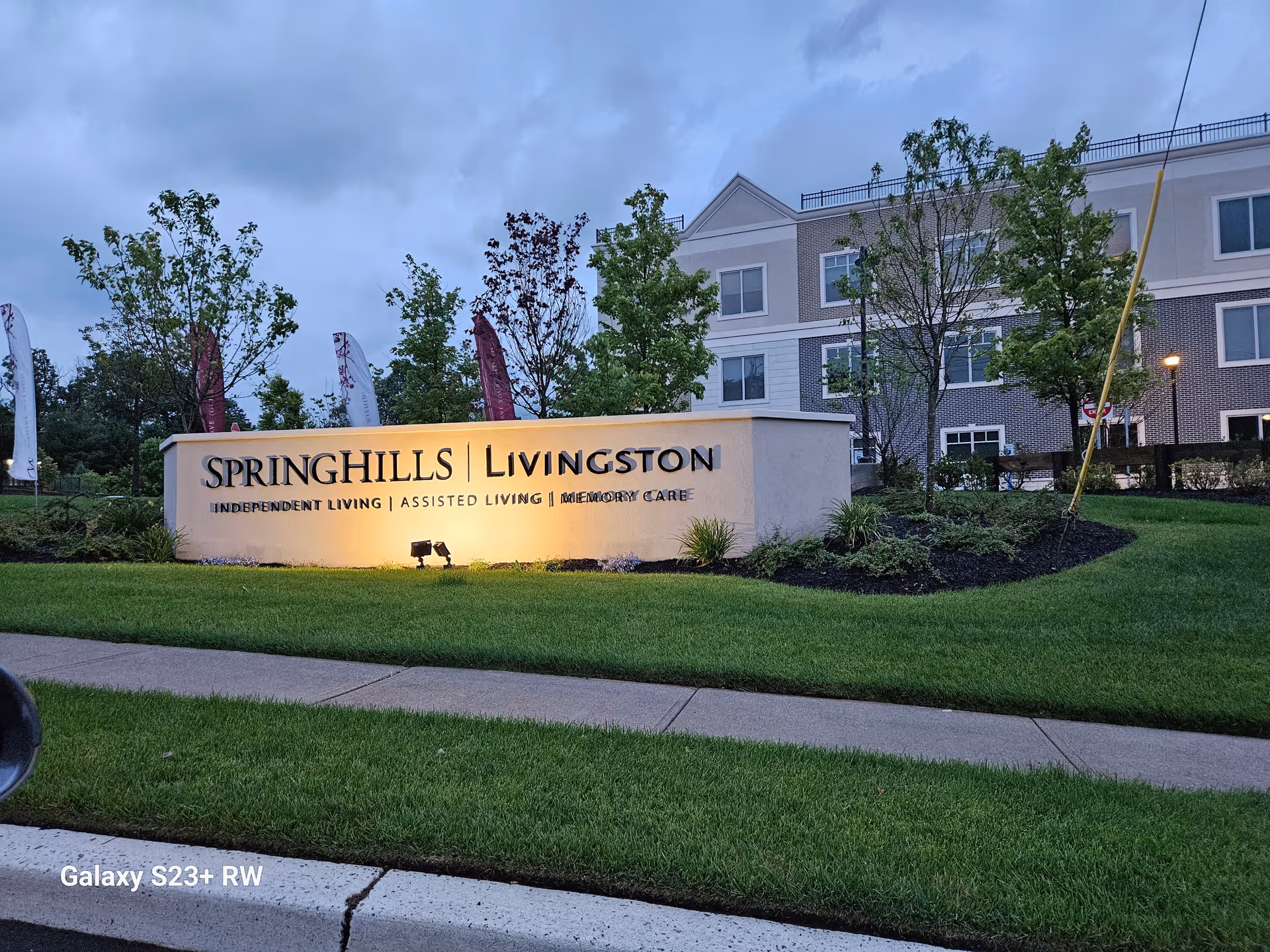 Exterior view of Spring Hills Livingston sign with a multi-story residential building behind.