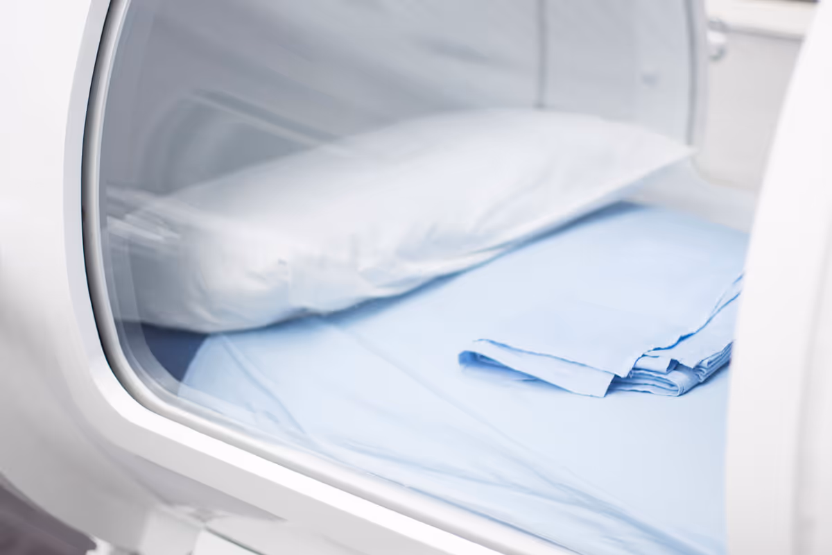 Close-up of a front-loading laundry machine with folded blue linens inside.