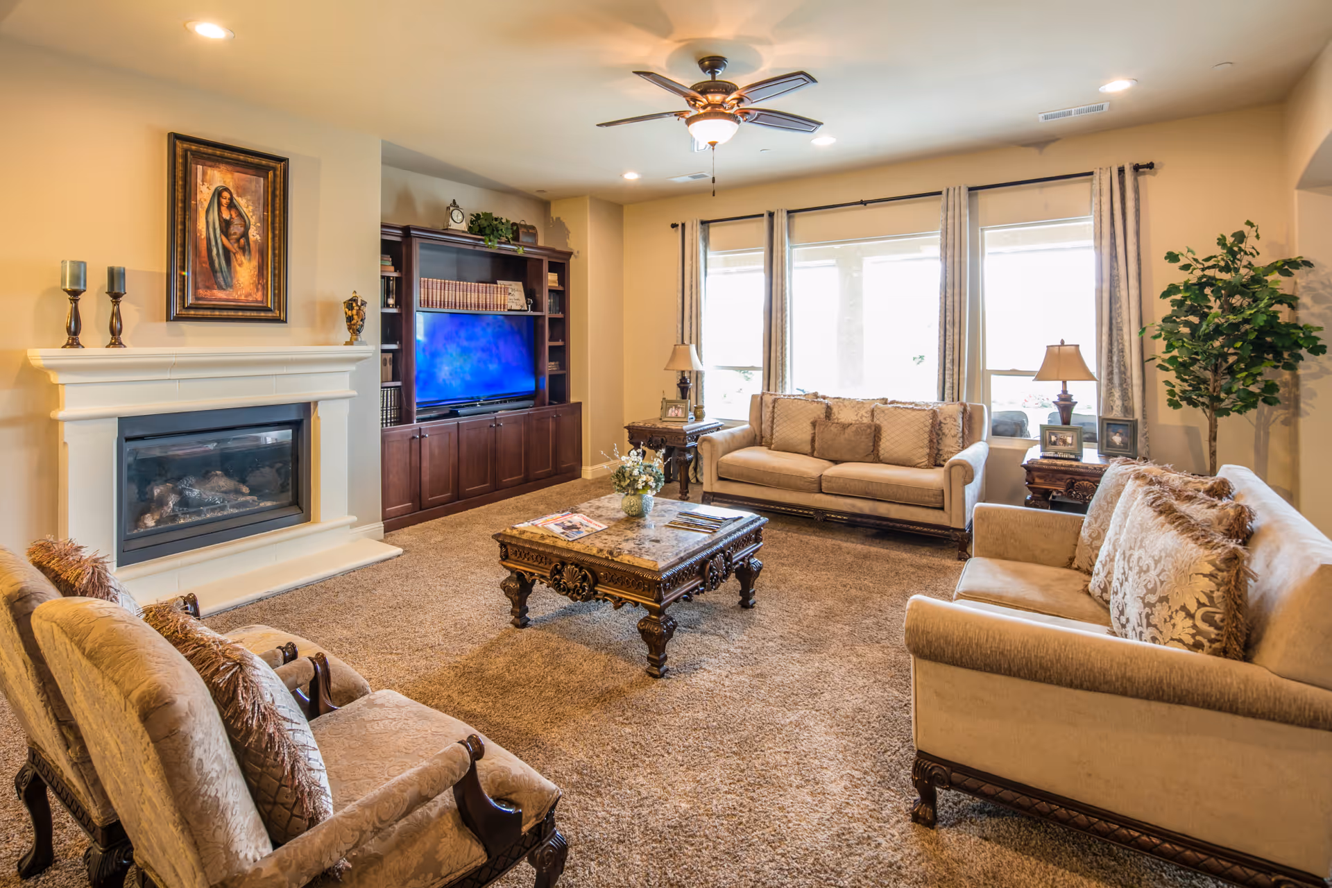 Cozy living room in a residential care facility with fireplace, TV, and large windows.