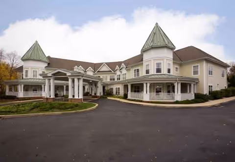 Exterior view of Sunrise of Granite Run, a senior living facility with towers and circular driveway.