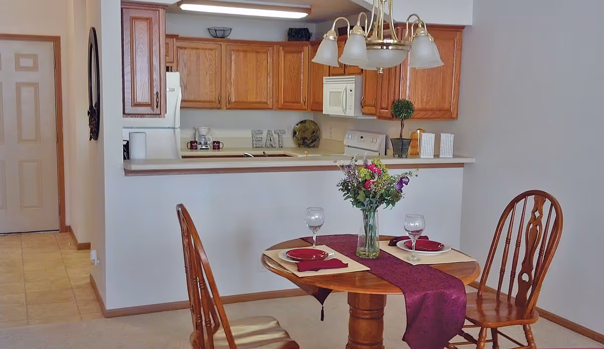 A dining table set for two in a kitchen-adjacent dining area.
