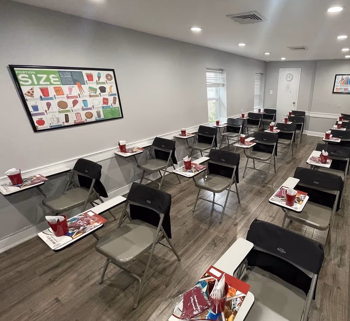 Interior classroom-style room at Hope Home Care with rows of folding chairs and desks.