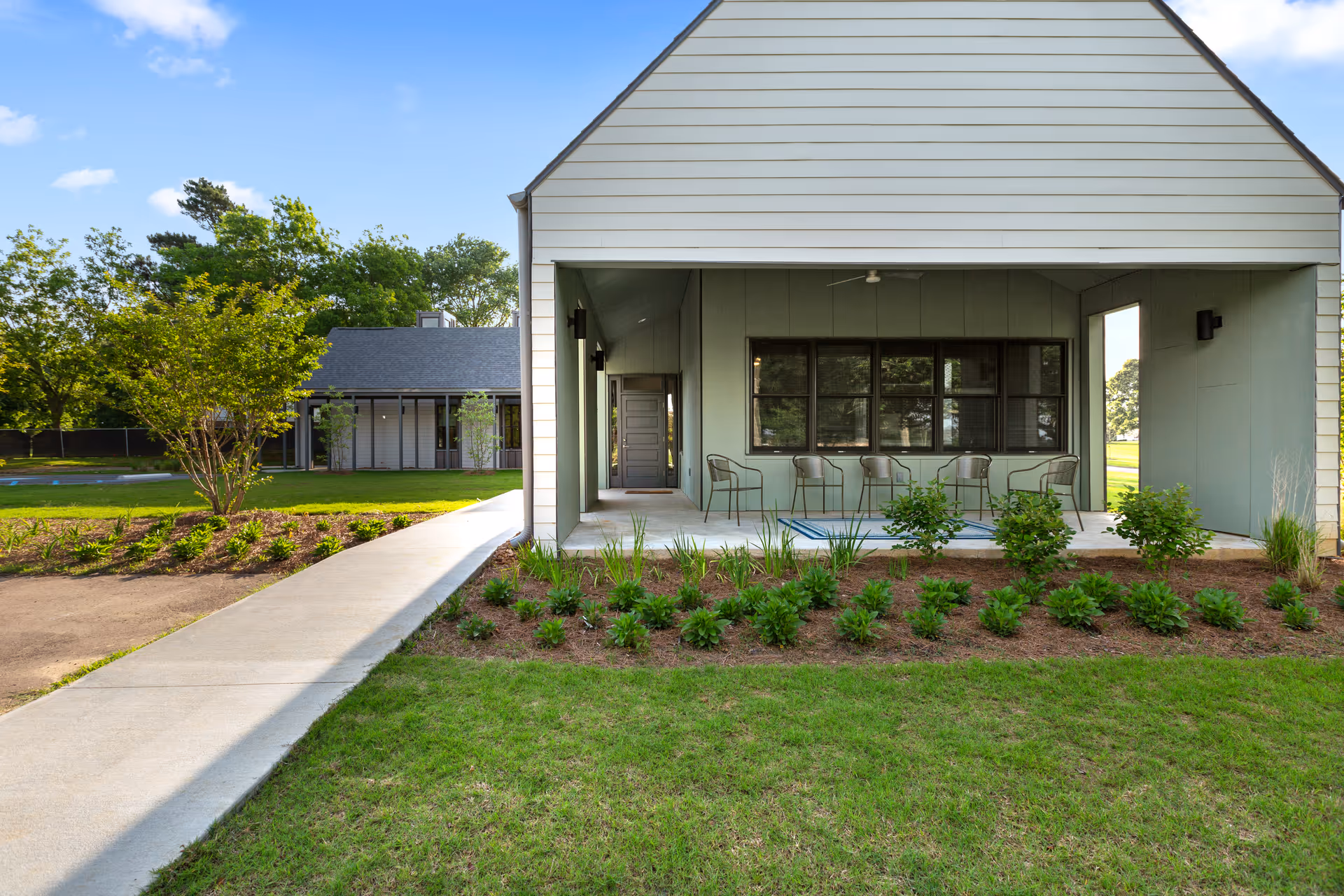 Front view of a modern senior living center with a covered porch and manicured landscaping.