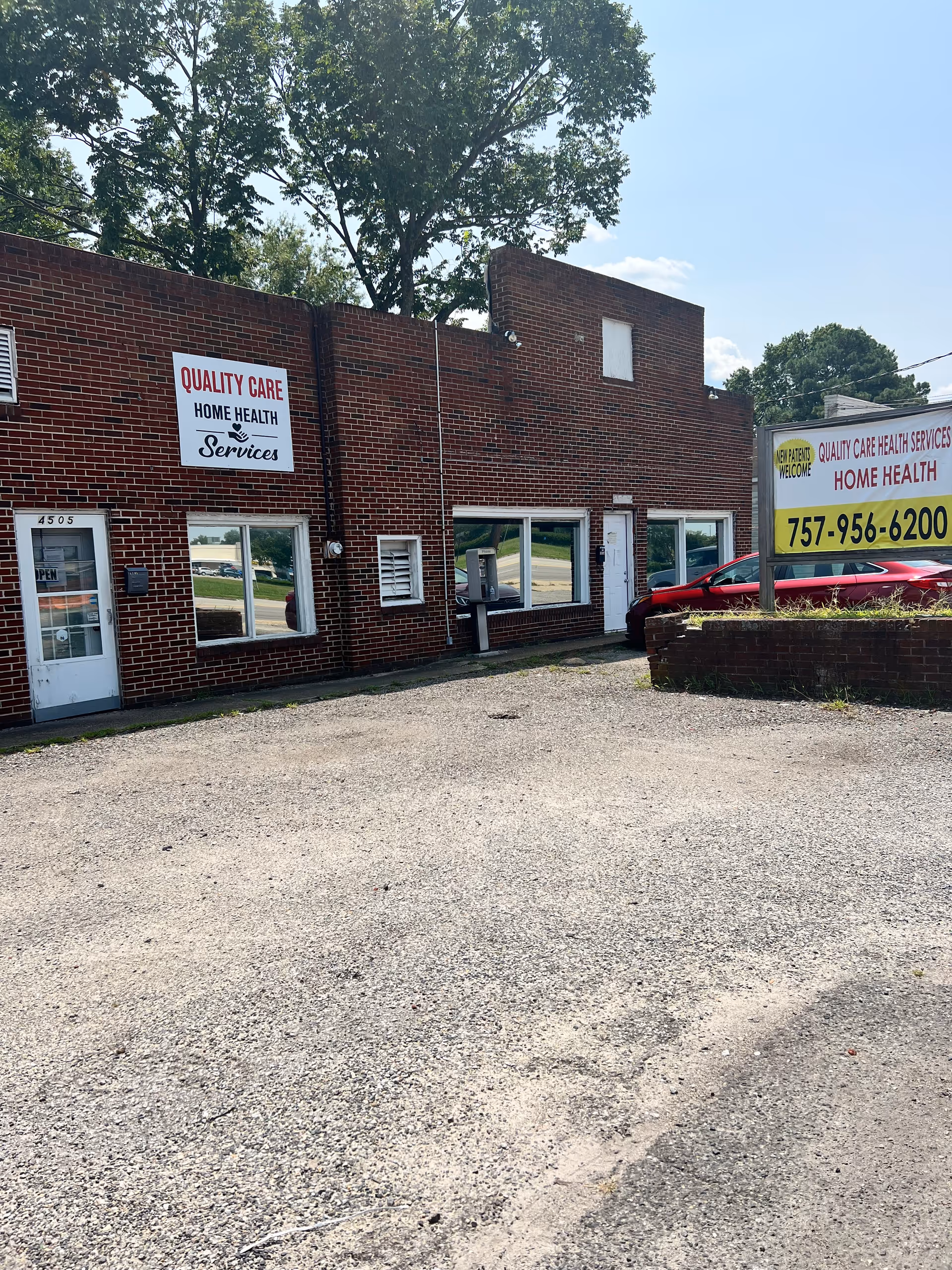 Brick building exterior with Quality Care Home Health Services signage and a parking area.