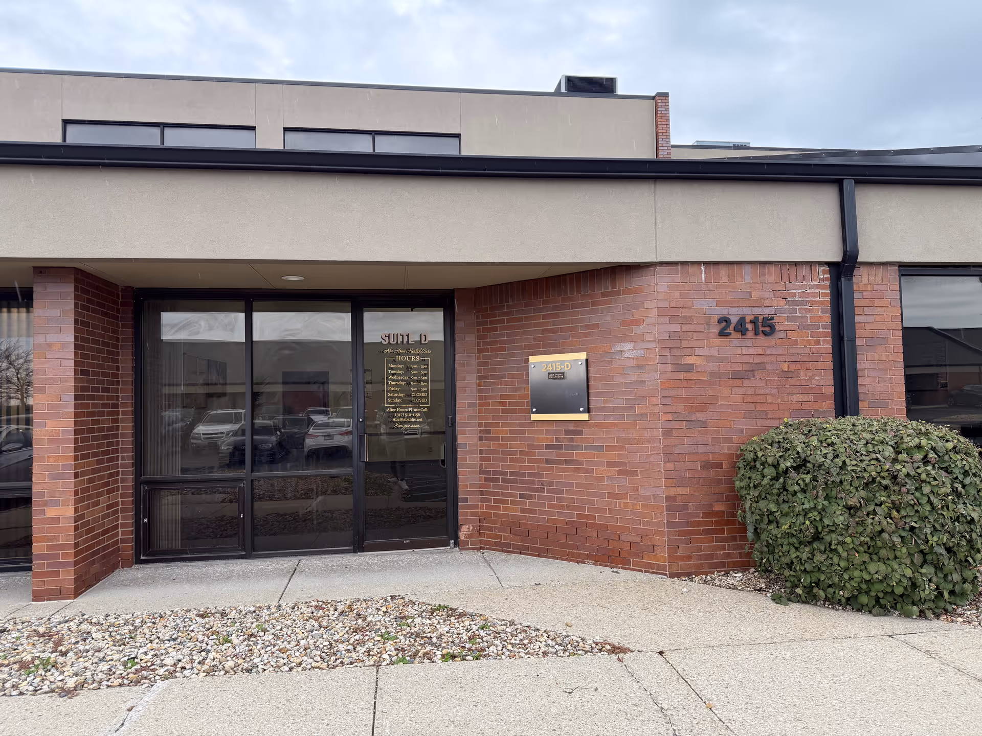 Brick building entrance with glass doors and visible address 2415.