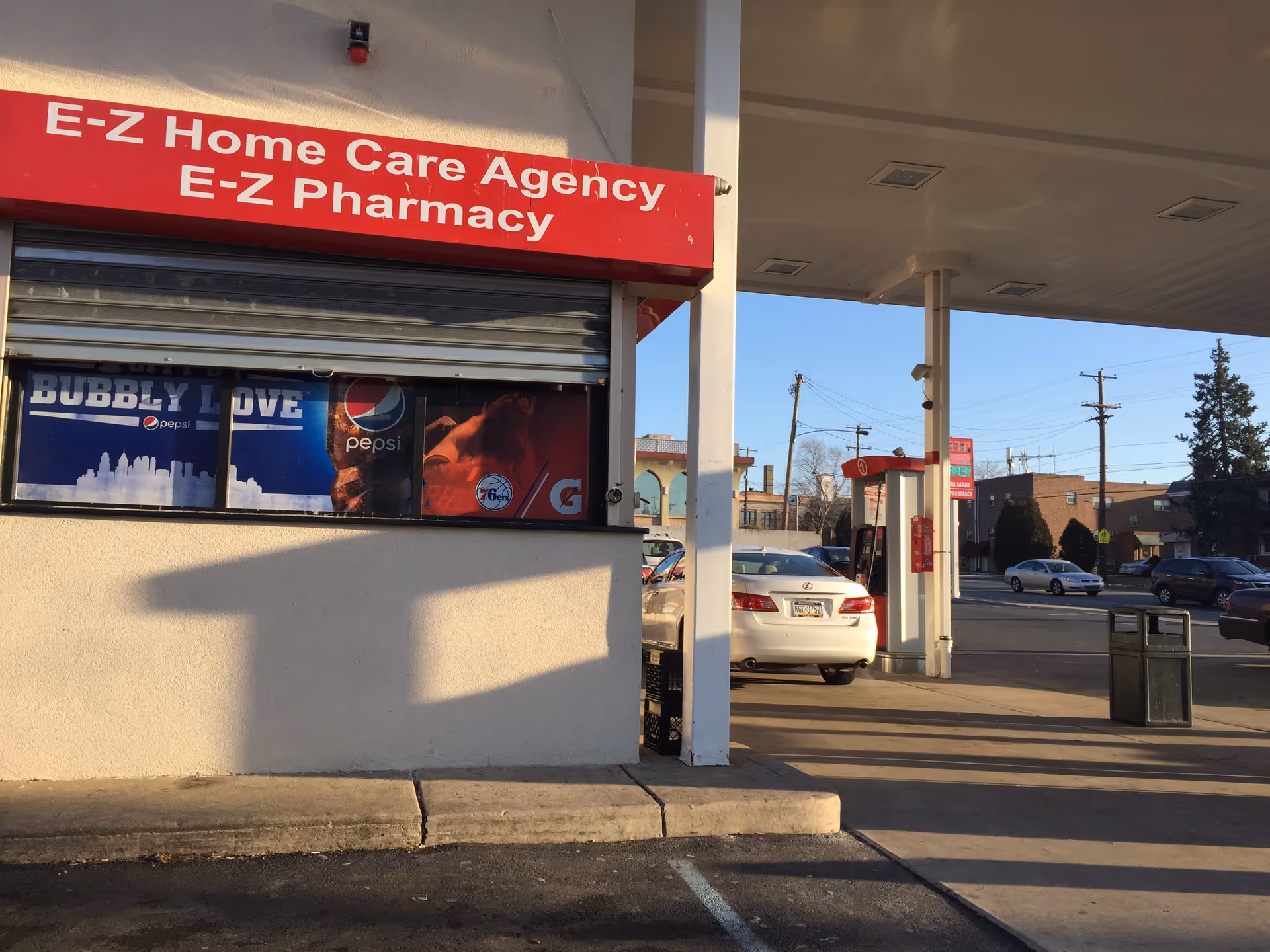 Exterior view of E-Z Home Care Agency and E-Z Pharmacy storefront with a parked car.