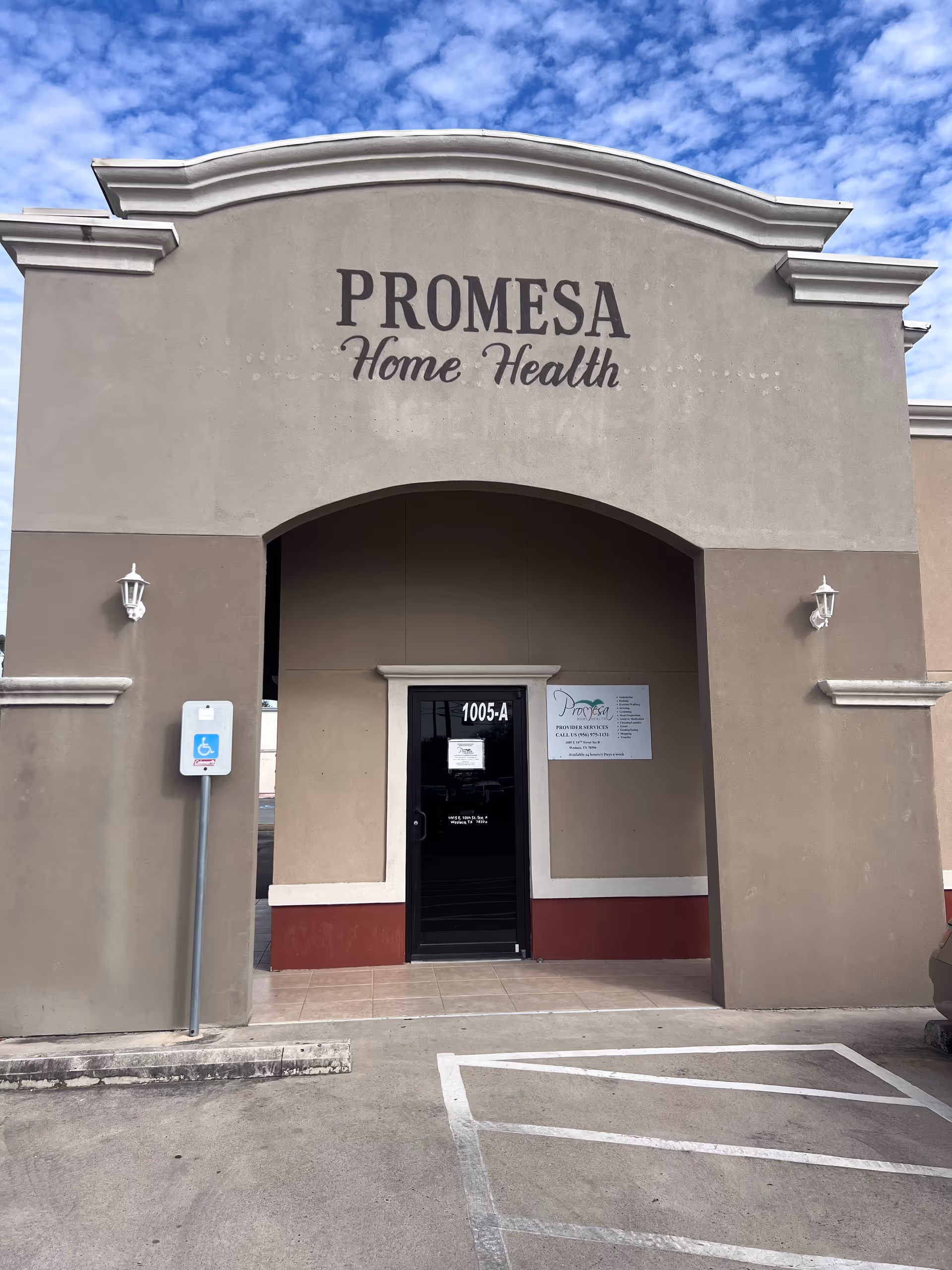 Front view of Promesa Home Health building entrance with archway and parking area.