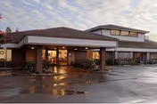 Exterior view of Pine Creek Care Center with a covered entrance and parking lot.