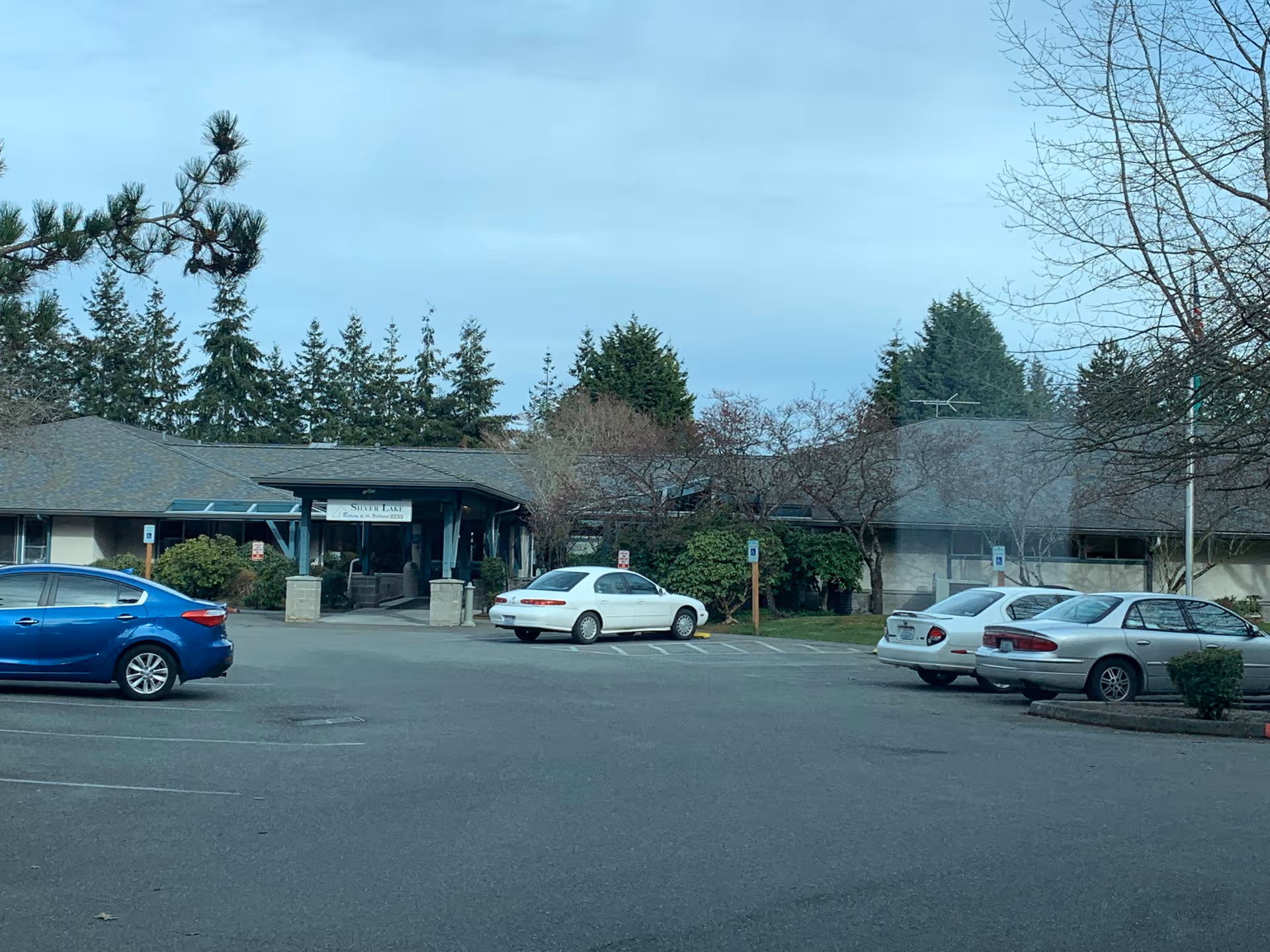 Exterior view of Bethany at Silvercrest entrance with several parked cars.