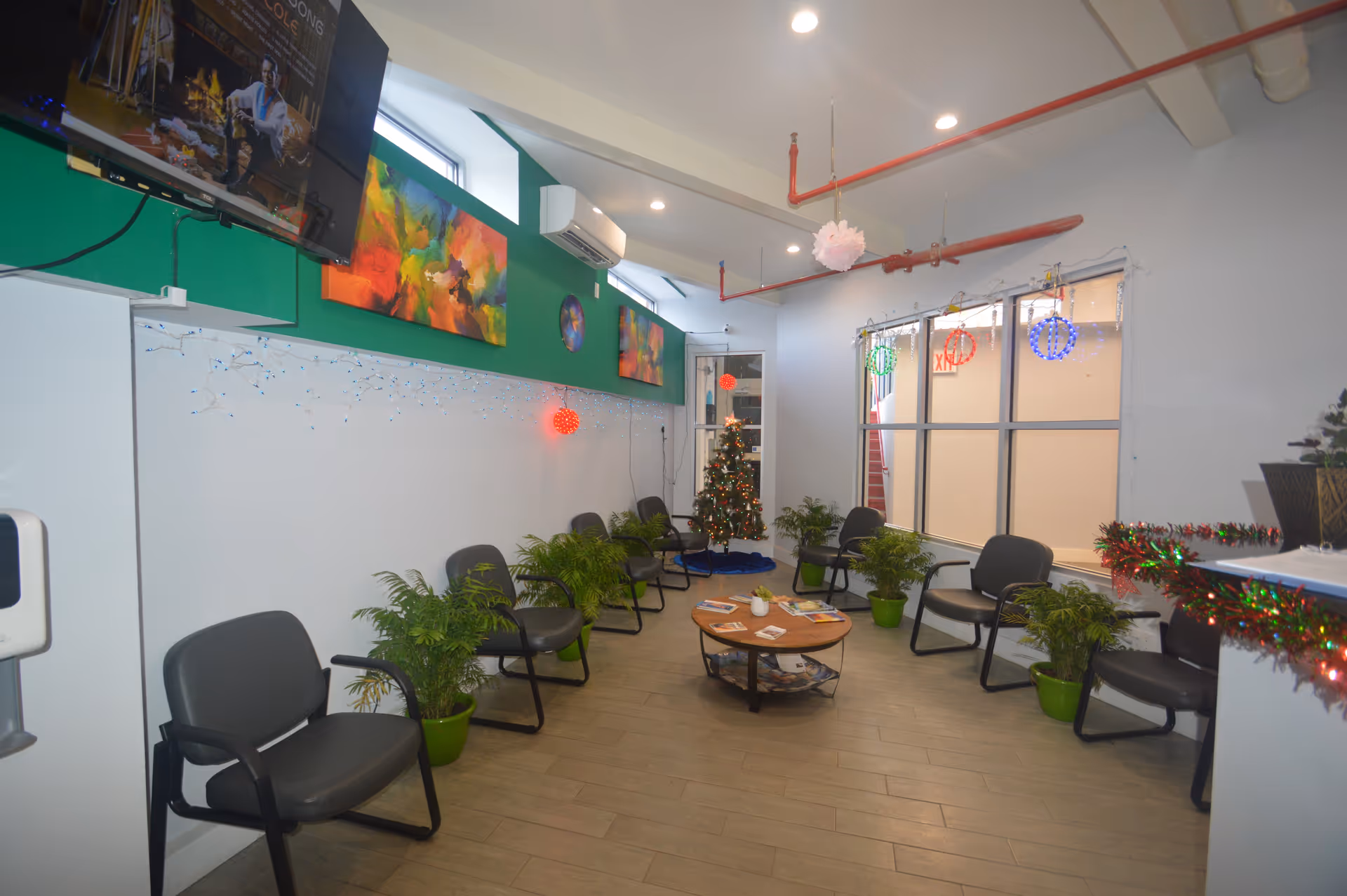 Senior living facility lobby with chairs, a central table, plants, and holiday decorations.