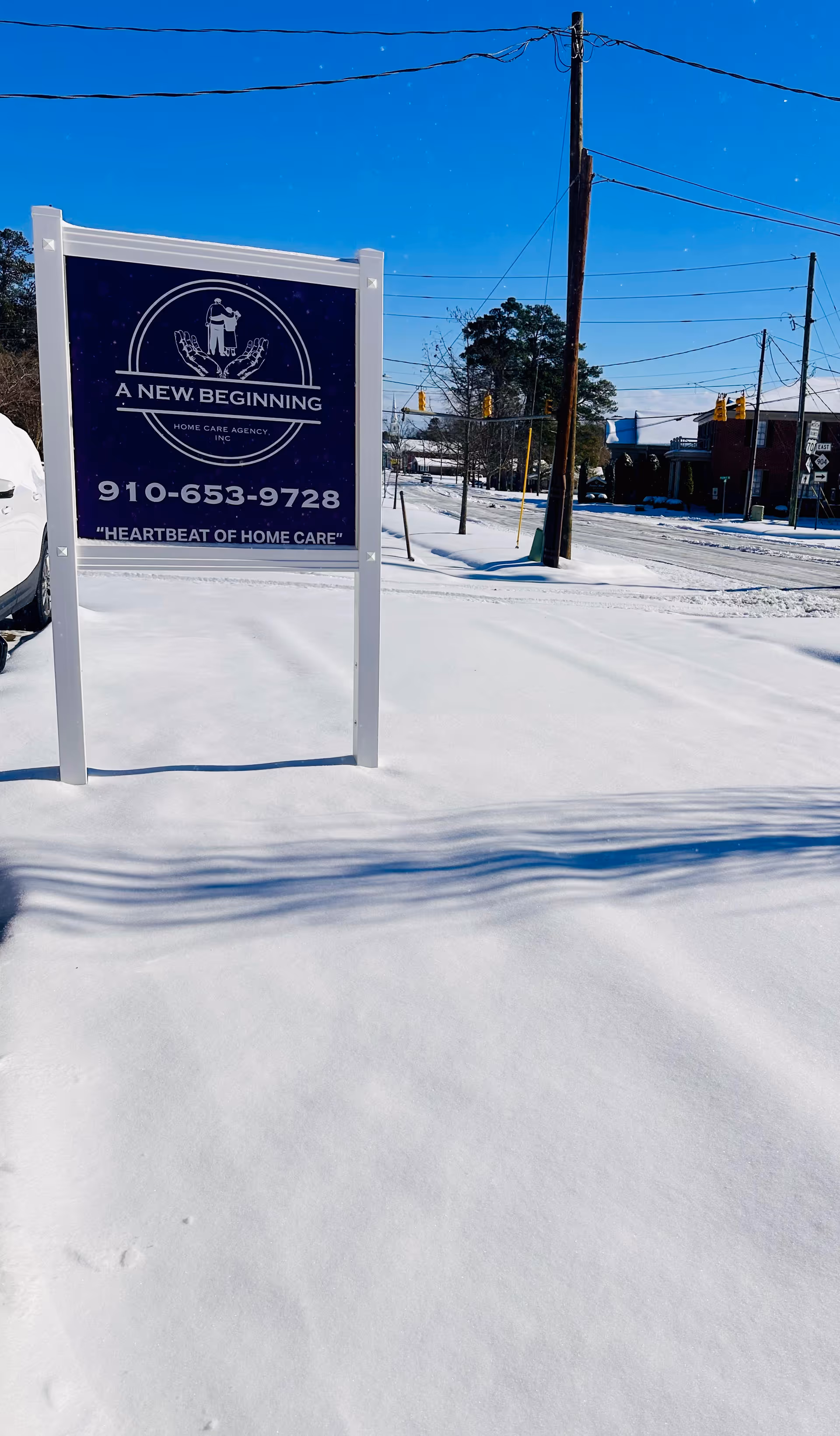 Snowy scene with a sign for A New Beginning Home Care Agency in front.