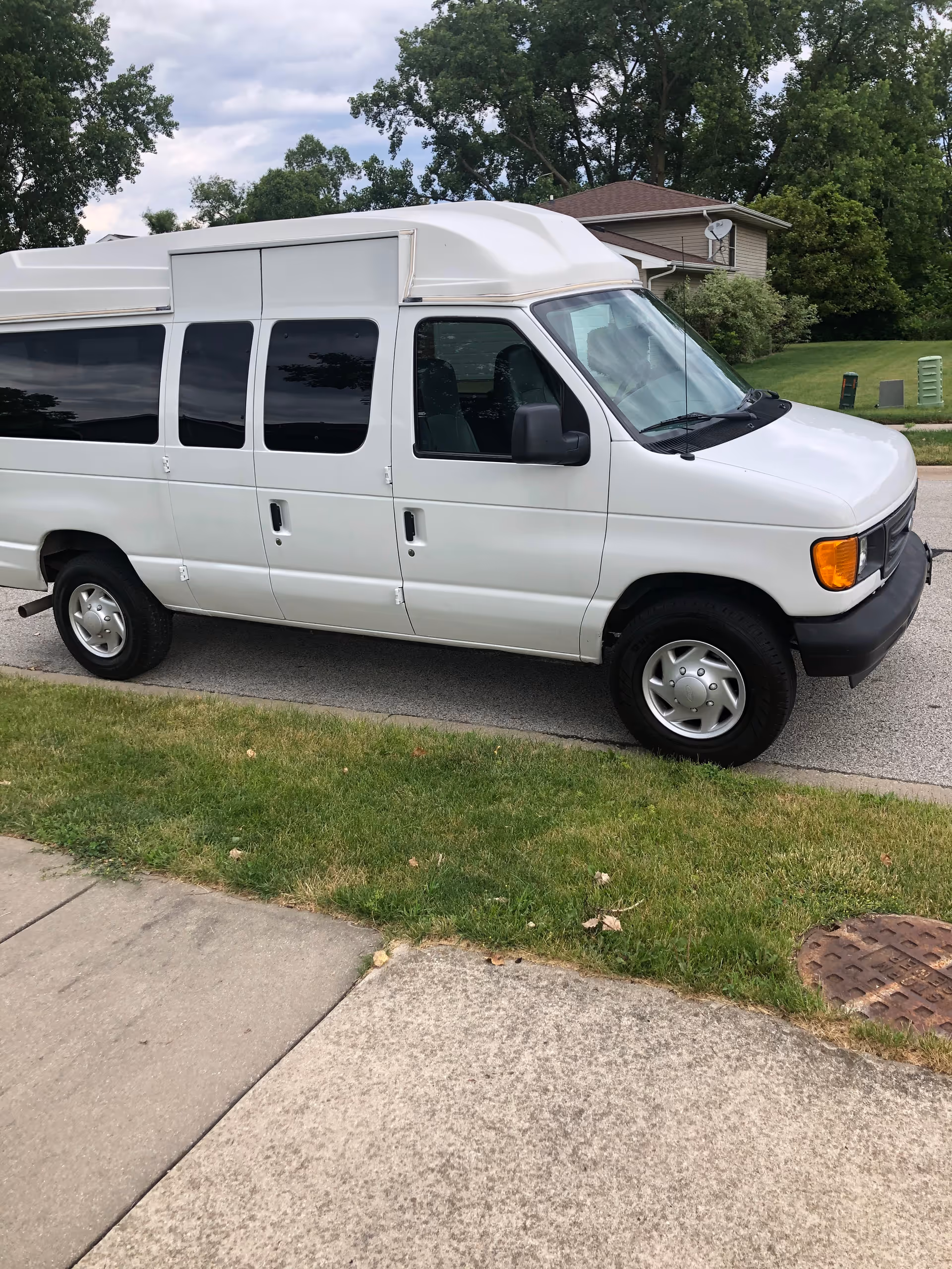 White passenger van parked on a quiet residential street.