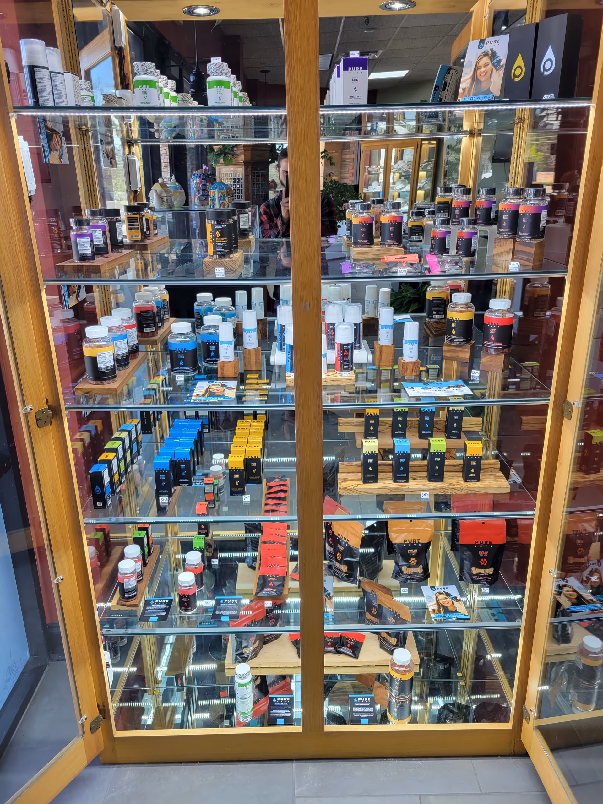 Glass display cabinet filled with assorted vitamin bottles inside an interior showroom.