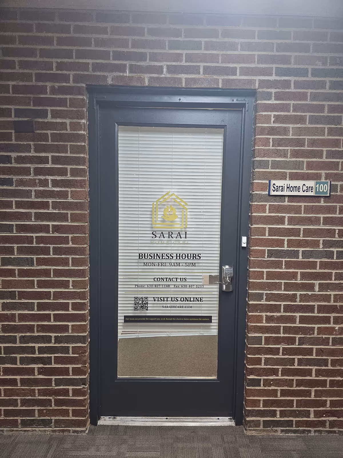 Brick exterior with a glass door displaying the Sarai Home Care logo