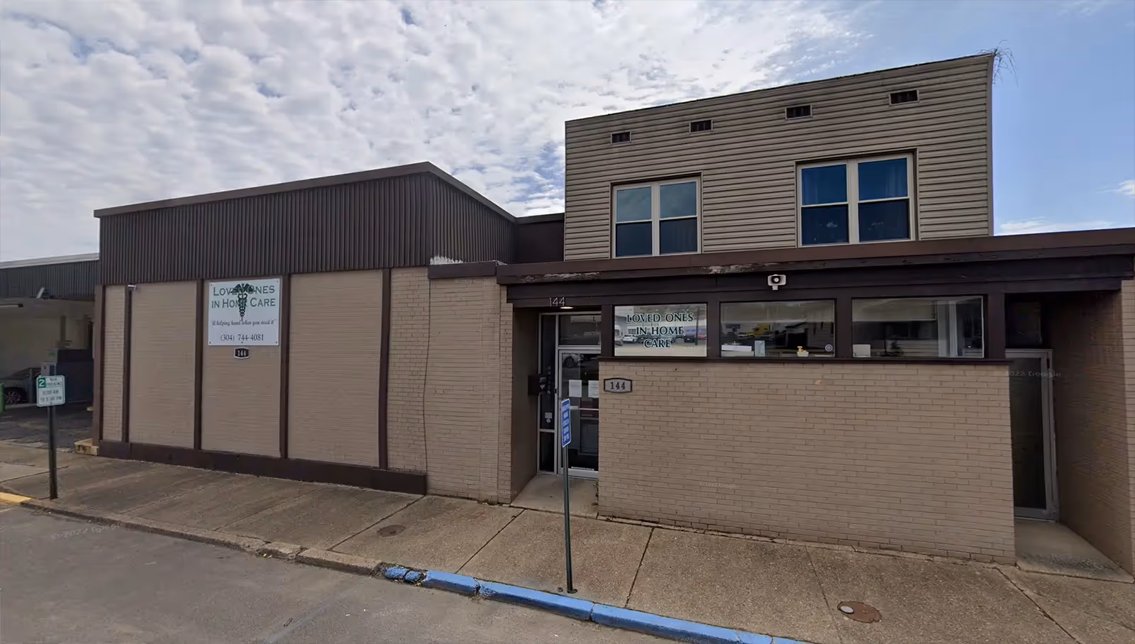 Front exterior of a beige brick building with Loved Ones In Home Care signage