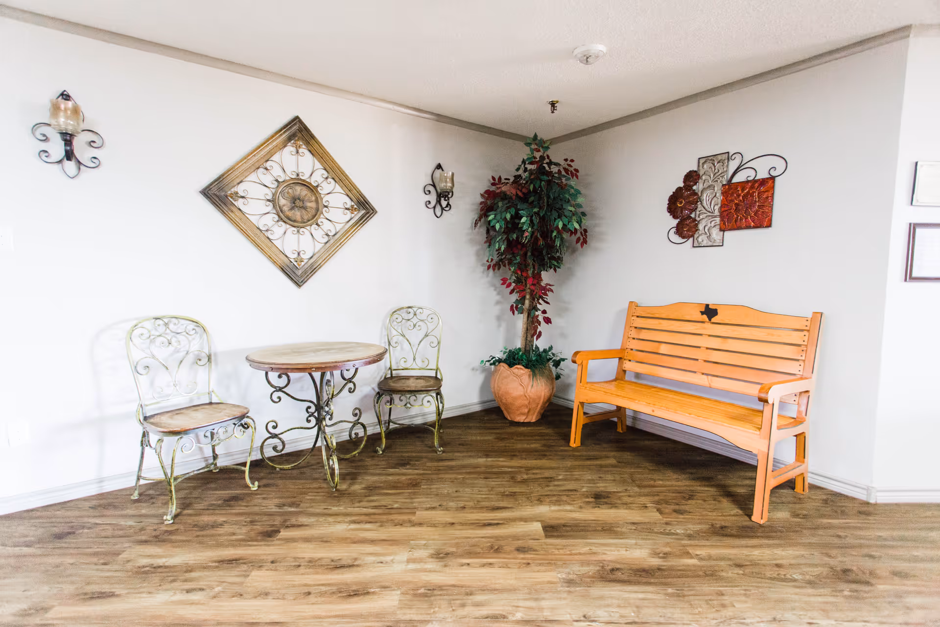 Rockwood Manor indoor seating area with a wooden bench, a round metal table, and two chairs.