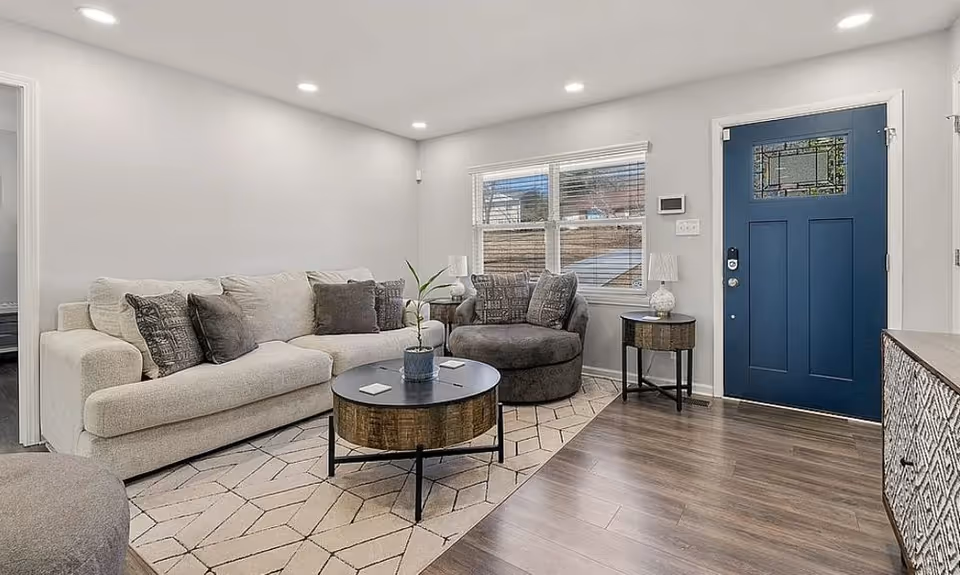 Cozy living room in a senior facility with sofa, chairs, coffee table, and blue door.