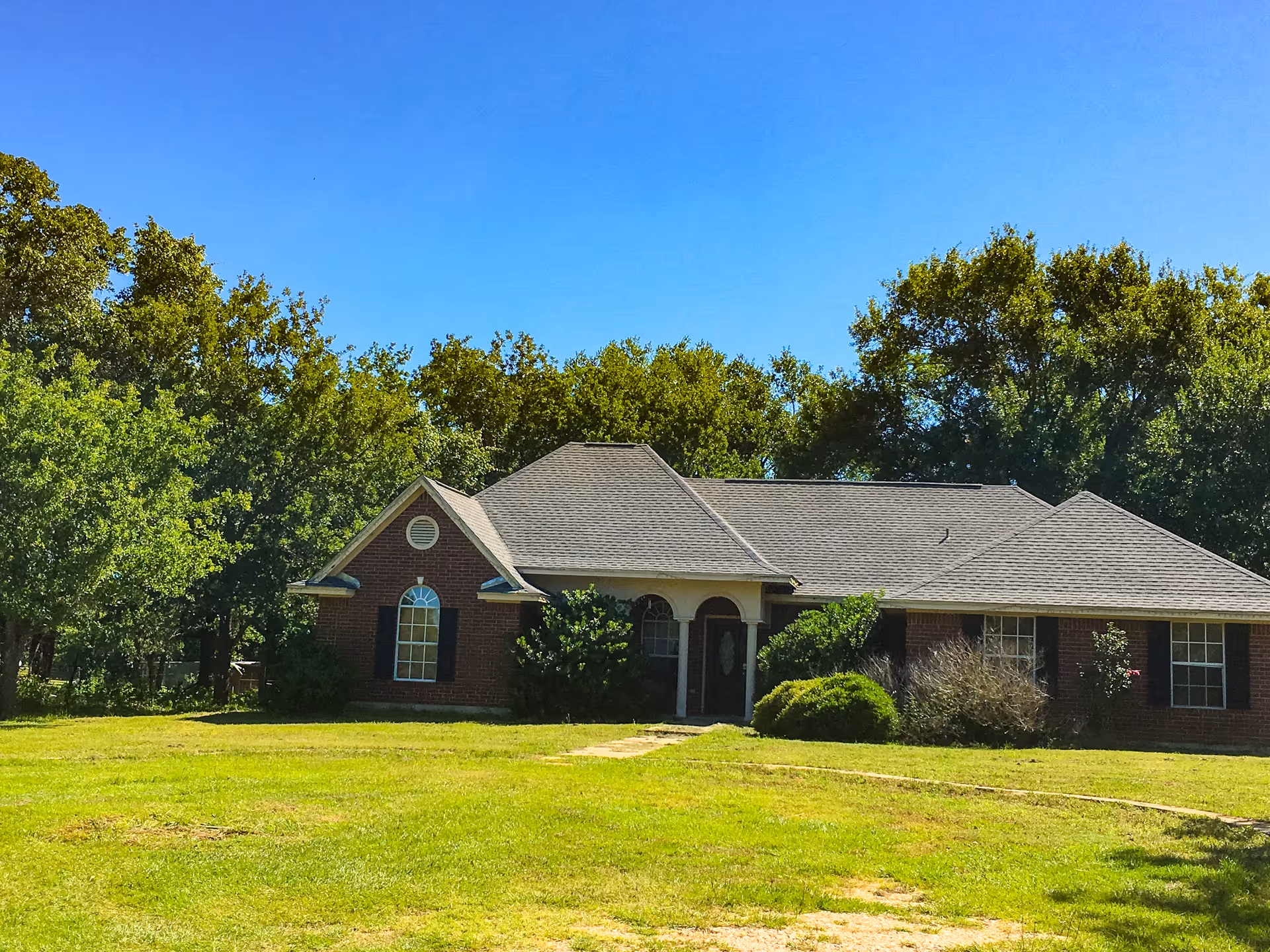 Single-story brick senior living facility with a front entrance and surrounding lawn.