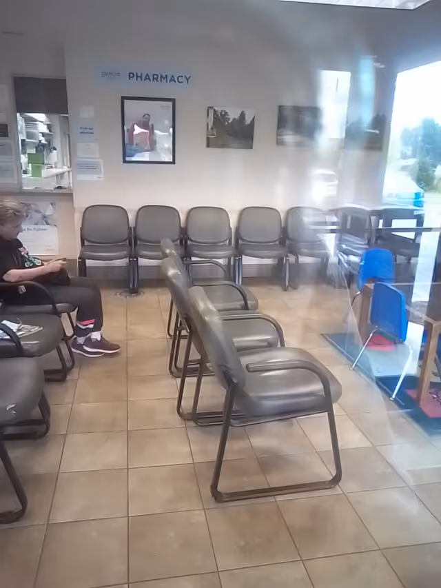 Bridge Health waiting area with lined chairs and a person seated near the wall.