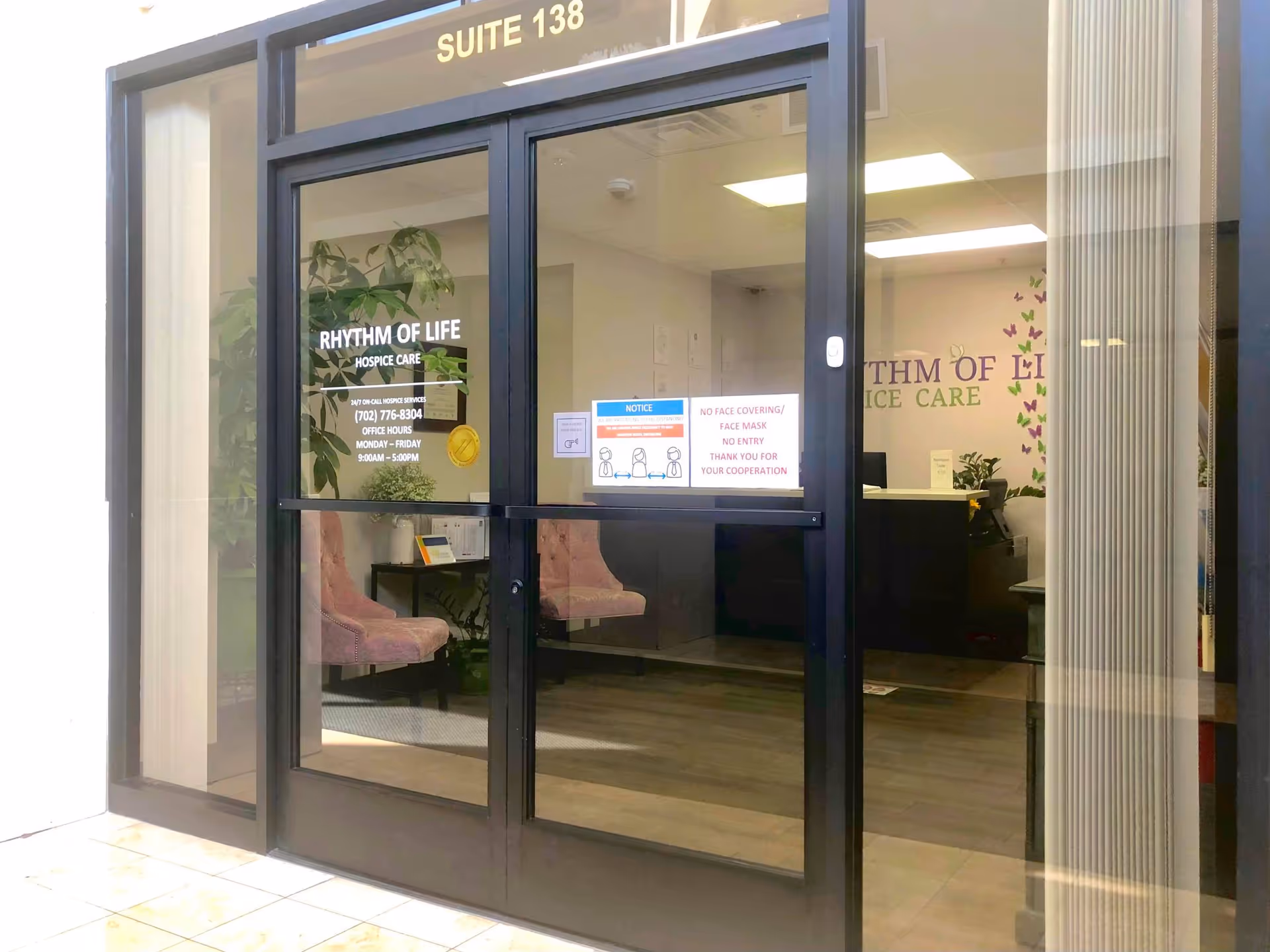 Glass storefront entrance with Rhythm of Life Hospice Care signage and waiting area visible inside.