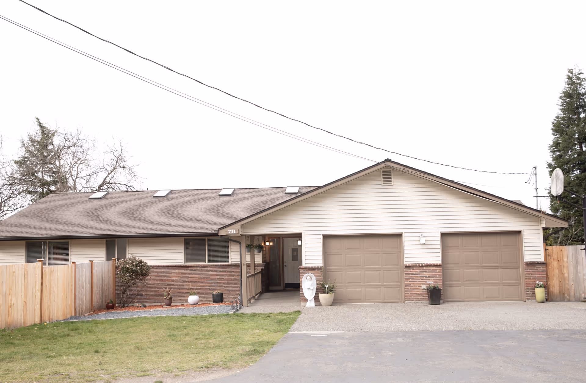Front exterior of a single-story facility with two brown garage doors and a driveway.